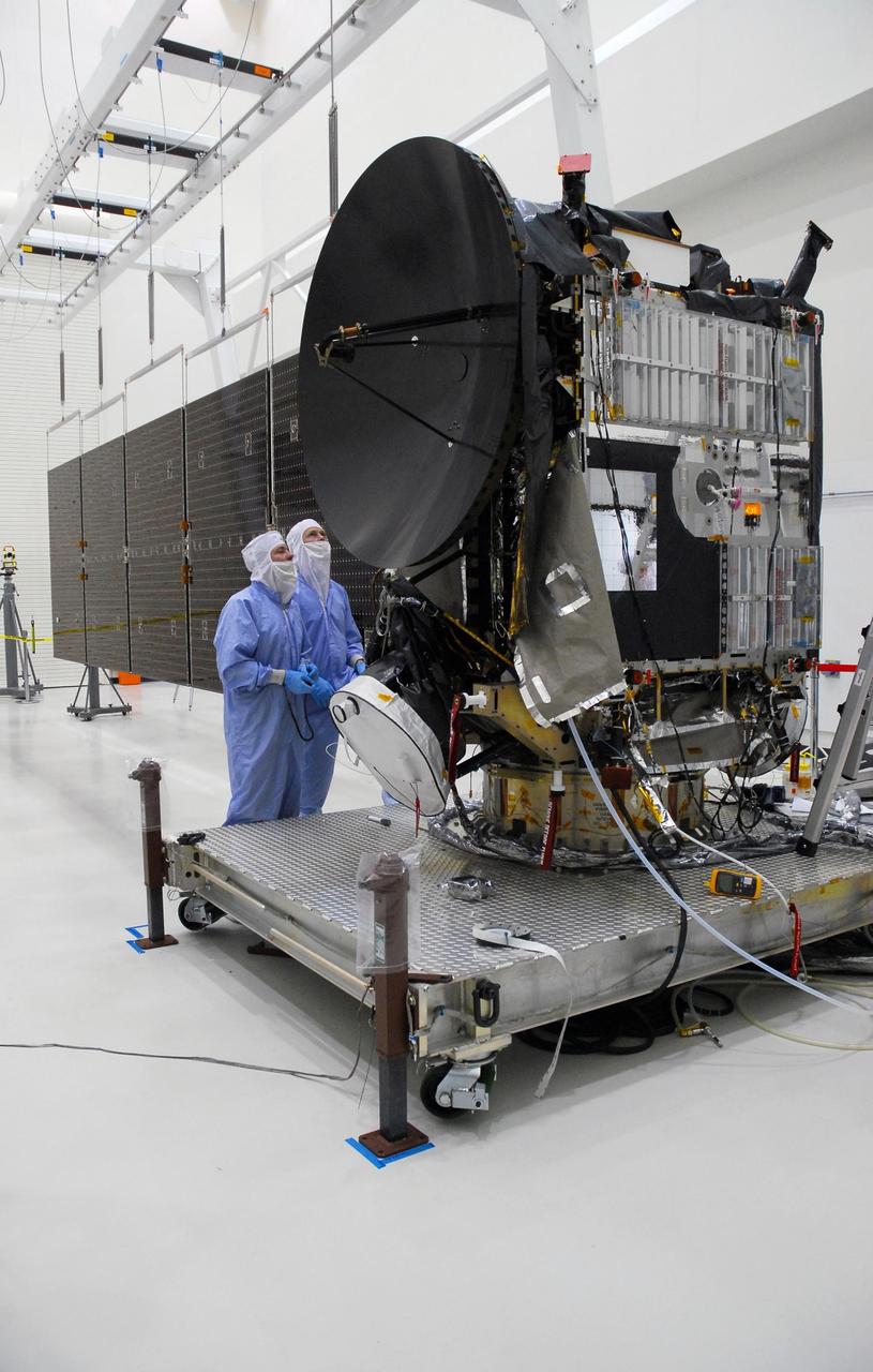 KENNEDY SPACE CENTER, FLA. --   At Astrotech, two Dutch technicians examine the Dawn spacecraft after deployment of the solar panels on one side.  Dawn is scheduled to launch June 30 aboard a Delta II rocket from Launch Complex 17-B at Cape Canaveral Air Force Station.   Dawn's mission is to explore two of the asteroid belt's most intriguing and dissimilar occupants: asteroid Vesta and the dwarf planet Ceres.  Photo credit: NASA/George Shelton