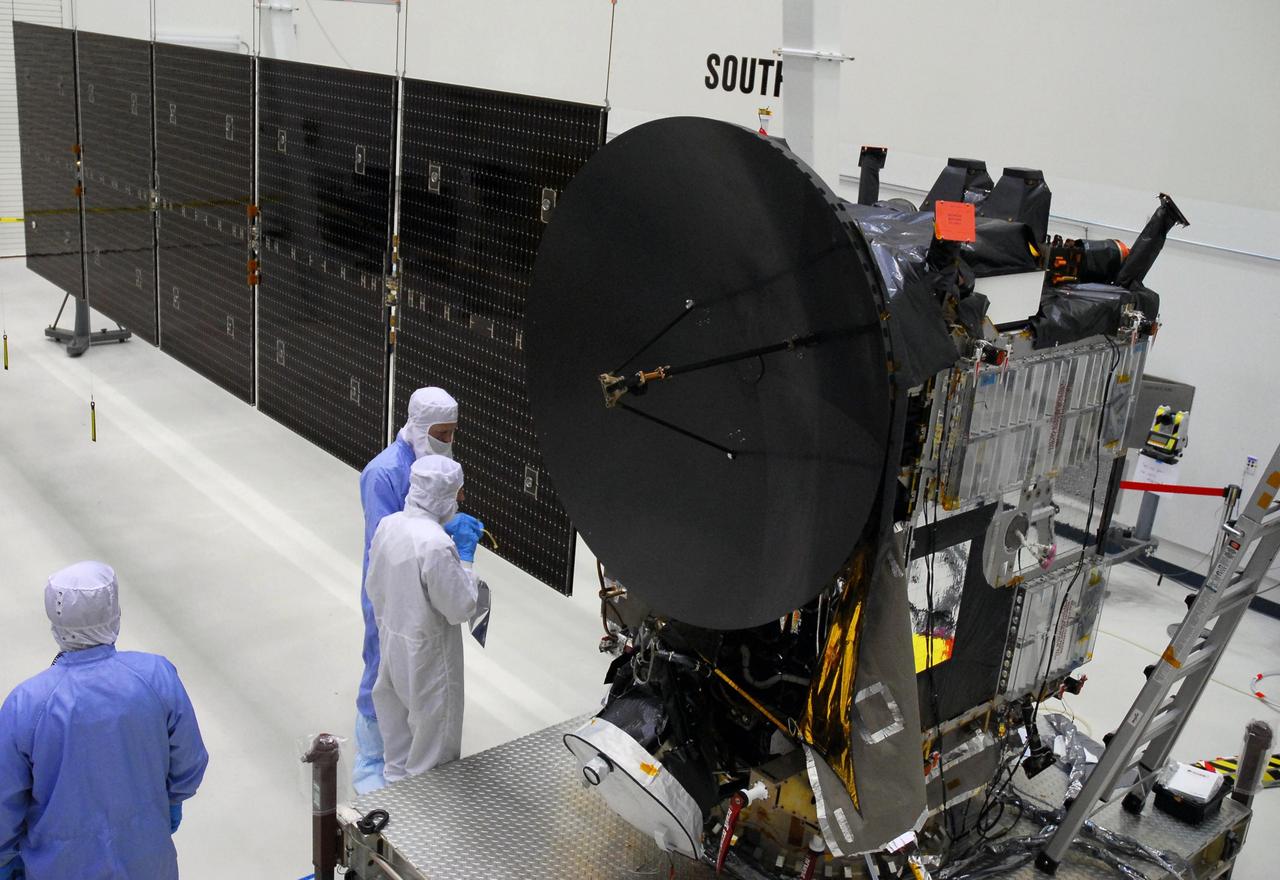 KENNEDY SPACE CENTER, FLA. --  At Astrotech, workers check the Dawn spacecraft after testing the deployment of its more than 32-foot-long solar panels on one side. Dawn's mission is to explore two of the asteroid belt's most intriguing and dissimilar occupants: asteroid Vesta and the dwarf planet Ceres.  Dawn is scheduled to launch June 30 aboard a Delta II rocket from Launch Complex 17-B at Cape Canaveral Air Force Station.  Photo credit: NASA/George Shelton