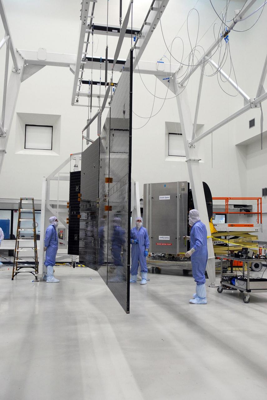 KENNEDY SPACE CENTER, FLA. --  At Astrotech, a suspended set of solar array panels is opened prior to installation on the Dawn spacecraft.  Another set was installed previously. Dawn is scheduled to launch June 30 aboard a Delta II rocket from Launch Complex 17-B at Cape Canaveral Air Force Station.   Dawn's mission is to explore two of the asteroid belt's most intriguing and dissimilar occupants: asteroid Vesta and the dwarf planet Ceres.  Photo credit: NASA/George Shelton