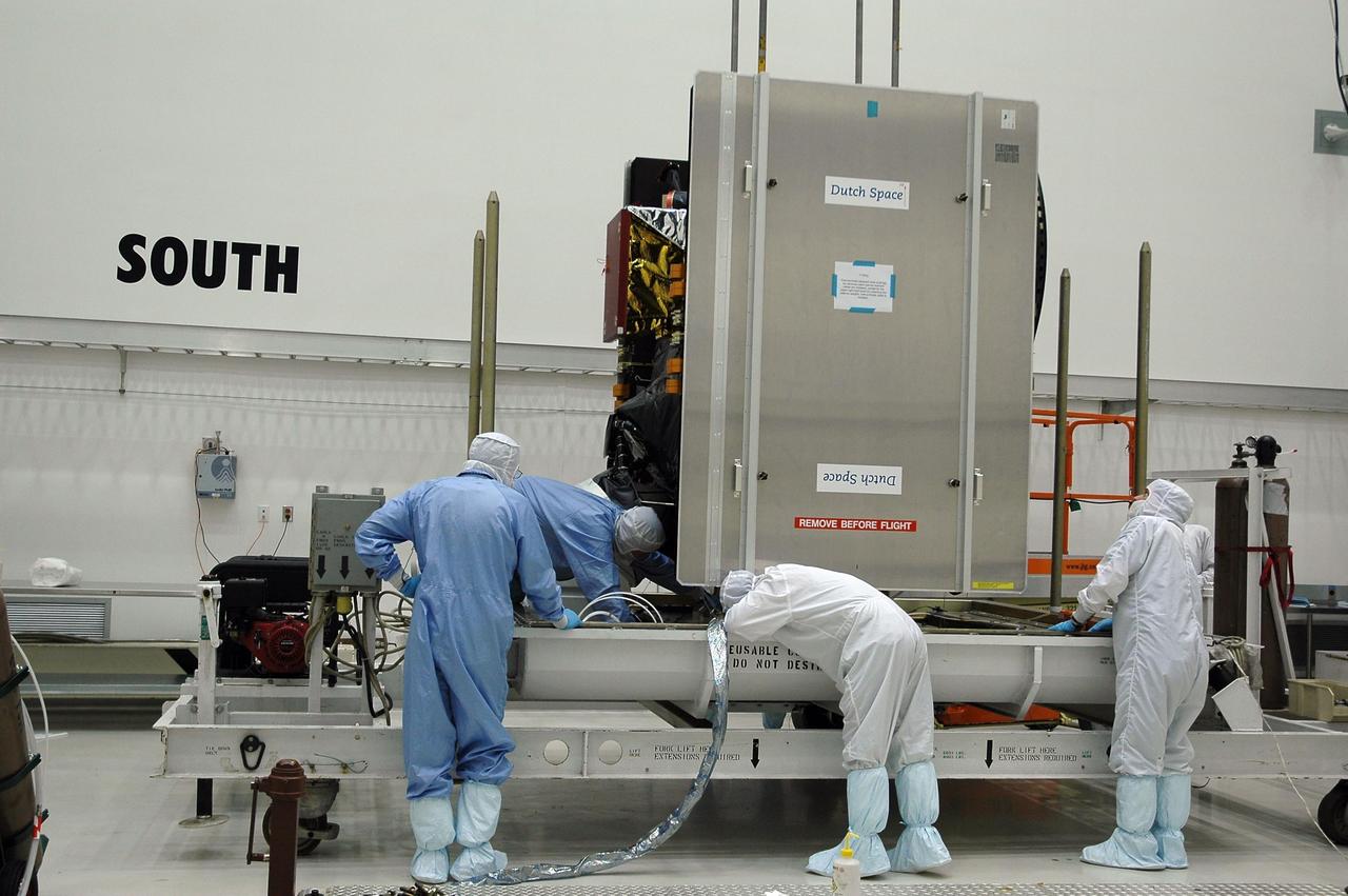 KENNEDY SPACE CENTER, FLA. -- At Astrotech's Payload Processing Facility, technicians check the Dawn spacecraft as it is lowered onto a transporter.  Dawn will be moved to the Hazardous Processing Facility for fueling.  Dawn is scheduled to launch June 30 aboard a Delta II rocket from Launch Complex 17-B at Cape Canaveral Air Force Station.  Dawn's mission is to explore two of the asteroid belt's most intriguing and dissimilar occupants: asteroid Vesta and the dwarf planet Ceres. Photo credit: NASA/Charisse Nahser