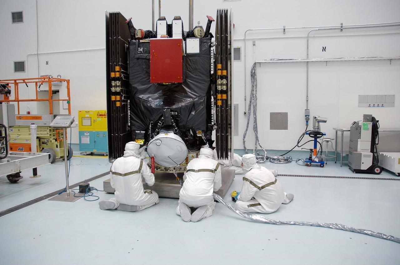 KENNEDY SPACE CENTER, FLA. -- Inside Astrotech's Hazardous Processing Facility, technicians check the Dawn spacecraft as it is lowered onto a scale for weighing.  Next, Dawn will be prepared for fueling.  Dawn is scheduled to launch June 30 aboard a Delta II rocket from Launch Complex 17-B at Cape Canaveral Air Force Station.  Dawn's mission is to explore two of the asteroid belt's most intriguing and dissimilar occupants: asteroid Vesta and the dwarf planet Ceres. Photo credit: NASA/Charisse Nahser
