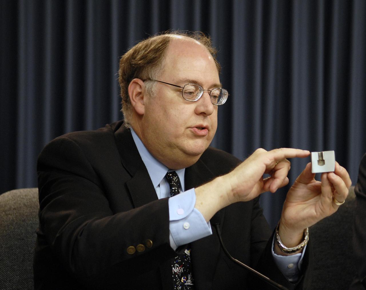 KENNEDY SPACE CENTER, FLA. --  Following the Flight Readiness Review for the STS-117 mission, NASA officials presented the decisions of NASA senior managers in a television conference.  Bill Gerstenmaier, associate administrator of NASA Space Operations Mission, confirmed the launch time and date of Space Shuttle Atlantis at 7:38 p.m. EDT on June 8.  Seen here is Space Shuttle Program Manager Wayne Hale (left) demonstrating the level of scrutiny engineers apply to inspecting the smallest of components that make up the shuttle system. This housing and bolt insert are part of the main engine low pressure oxidizer turbopump (LPOTP). Photo credit: NASA/Kim Shiflett