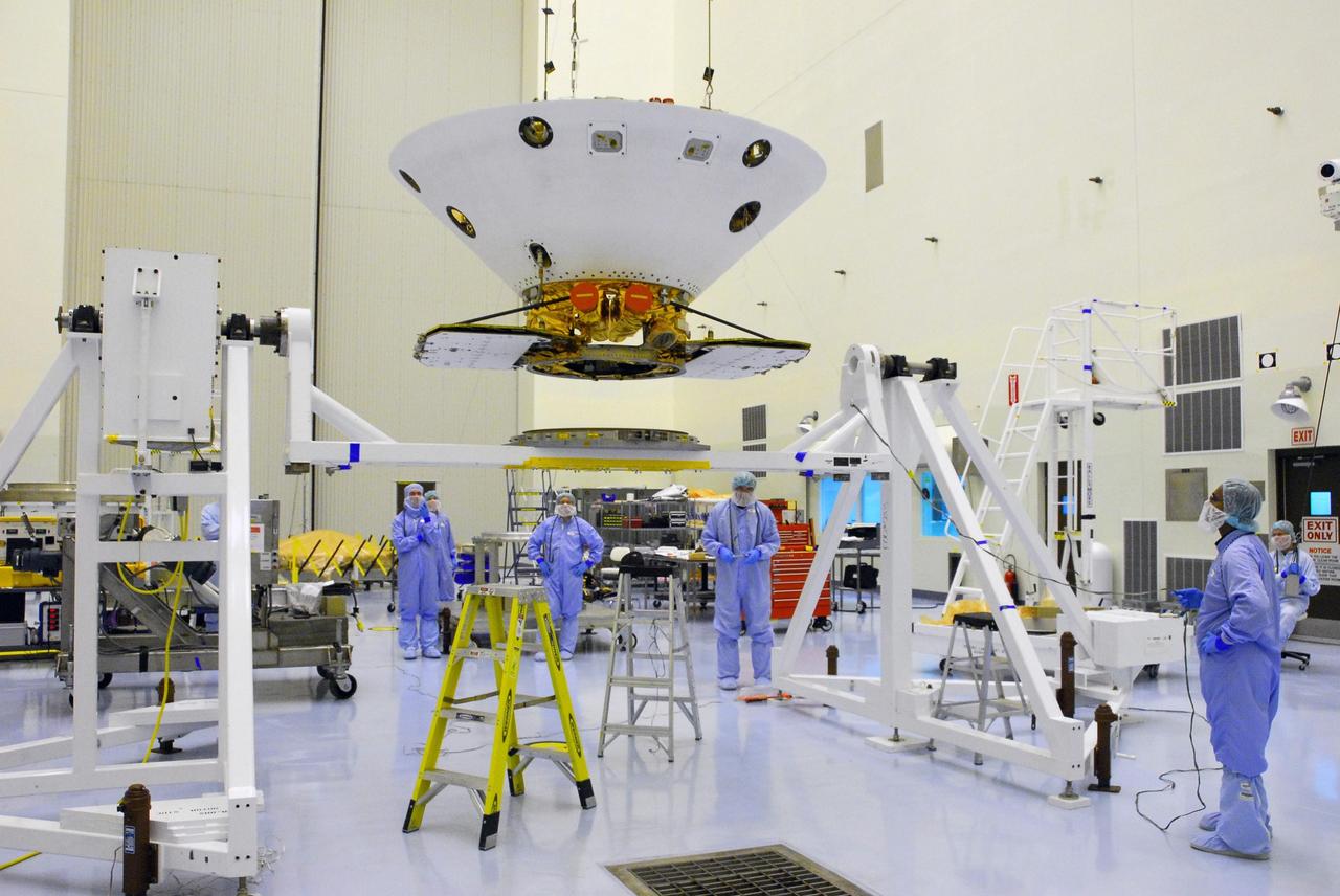 KENNEDY SPACE CENTER, FLA. -- In the Payload Handling Servicing Facility, an overhead crane lifts the Phoenix spacecraft from its stand for a move to a rotation stand for an interim weight and center of gravity determination. The Phoenix mission is the first project in NASA's first openly competed program of Mars Scout missions. Phoenix will land in icy soils near the north polar permanent ice cap of Mars and explore the history of the water in these soils and any associated rocks, while monitoring polar climate. Landing is planned in May 2008 on arctic ground where a mission currently in orbit, Mars Odyssey, has detected high concentrations of ice just beneath the top layer of soil. It will serve as NASA's first exploration of a potential modern habitat on Mars and open the door to a renewed search for carbon-bearing compounds, Photo credit: NASA/George Shelton
