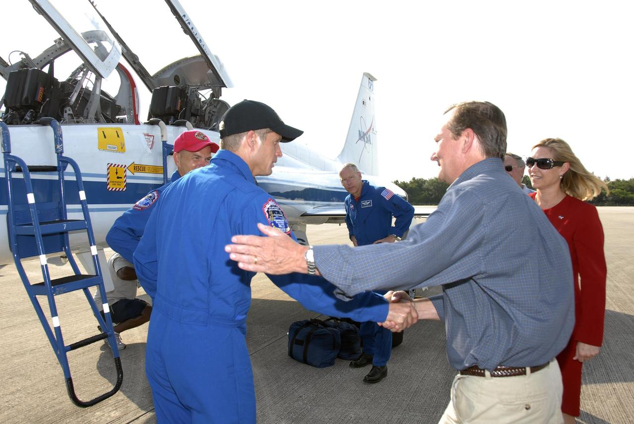 KENNEDY SPACE CENTER, FLA. -- The STS-117 crew members arrive at the KSC Shuttle Landing Facility aboard T-38 jet aircraft to prepare for launch on Space Shuttle Atlantis on June 8.  Mission Specialist Steven Swanson is greeted by Shuttle Launch Director Mike Leinbach.  Behind Swanson, at left, is Commander Frederick Sturckow; Mission Specialist Patrick Forrester is at center; Janet Petro, deputy director of Kennedy, is at right.  During the 11-day mission and three spacewalks, the crew will work with flight controllers at NASA's Johnson Space Center in Houston to install a 17-ton segment on the station's girder-like truss and deploy a set of solar arrays, S3/S4. The mission will increase the space station's power capability in preparation for the arrival of new science modules from the European and Japanese space agencies.    Photo credit: NASA/Kim Shiflett