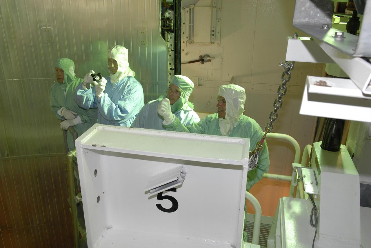 KENNEDY SPACE CENTER, FLA. -- After their arrival at KSC, STS-117 crew members take part in a payload bay walkdown on Launch Pad 39A to look at the cargo in Space Shuttle Atlantis. In the bucket are Mission Specialists Patrick Forrester (with camera) and Steven Swanson (far right). The payload includes the S3/S4 integrated truss structure for the International Space Station. STS-117 is scheduled to launch at 7:38 p.m. June 8.  During the 11-day mission and three spacewalks, the crew will work with flight controllers at NASA's Johnson Space Center in Houston to install the 17-ton segment on the station's girder-like truss and deploy the set of solar arrays, S3/S4. The mission will increase the space station's power capability in preparation for the arrival of new science modules from the European and Japanese space agencies.    Photo credit: NASA/Kim Shiflett