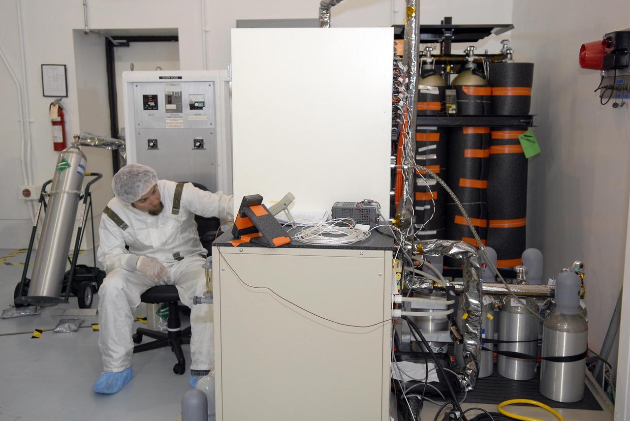 KENNEDY SPACE CENTER, FLA. -- In Astrotech's Hazardous Processing Facility, a technician monitors the loading of xenon for the ion propulsion system in the Dawn spacecraft. Dawn's mission is to explore two of the asteroid belt's most intriguing and dissimilar occupants: asteroid Vesta and the dwarf planet Ceres. The Dawn spacecraft uses ion propulsion to get the additional velocity needed to reach Vesta once it leaves the Delta rocket. It also uses ion propulsion to spiral to lower altitudes on Vesta, to leave Vesta and cruise to Ceres and to spiral to a low-altitude orbit at Ceres. Ion propulsion makes efficient use of the onboard fuel by accelerating it to a velocity 10 times that of chemical rockets. Dawn is scheduled to launch July 7aboard a Delta II rocket from Launch Complex 17-B at Cape Canaveral Air Force Station. Photo credit: NASA/Kim Shiflett