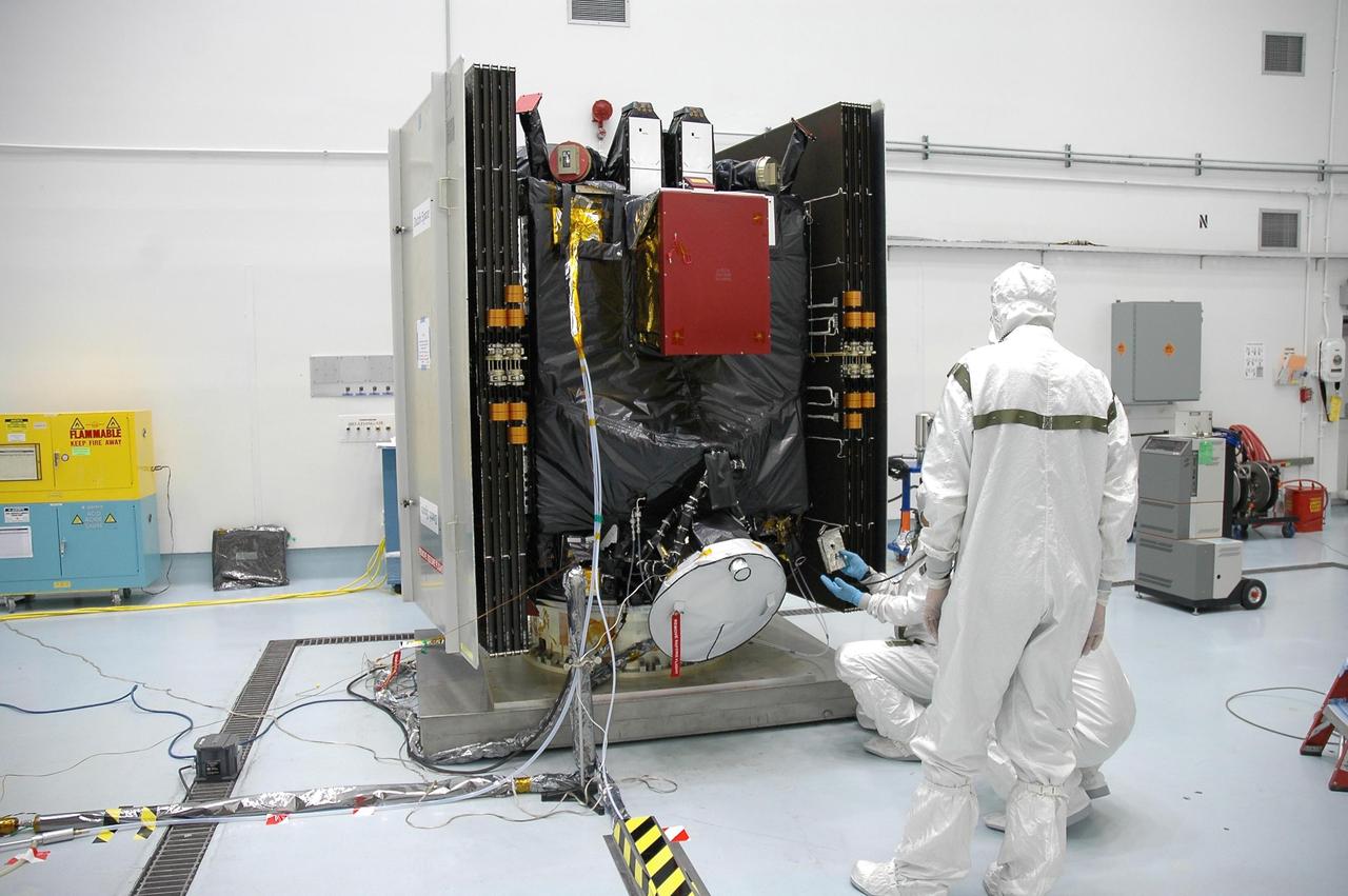 KENNEDY SPACE CENTER, FLA. --  At Astrotech's Hazardous Processing Facility, technicians are loading the Dawn spacecraft with xenon gas for the ion propulsion system.  Dawn's mission is to explore two of the asteroid belt's most intriguing and dissimilar occupants: asteroid Vesta and the dwarf planet Ceres. The Dawn spacecraft uses ion propulsion to get the additional velocity needed to reach Vesta once it leaves the Delta rocket. It also uses ion propulsion to spiral to lower altitudes on Vesta, to leave Vesta and cruise to Ceres and to spiral to a low-altitude orbit at Ceres. Ion propulsion makes efficient use of the onboard fuel by accelerating it to a velocity 10 times that of chemical rockets.  Dawn is scheduled to launch July 7aboard a Delta II rocket from Launch Complex 17-B at Cape Canaveral Air Force Station.   Photo credit: NASA/Jim Grossmann