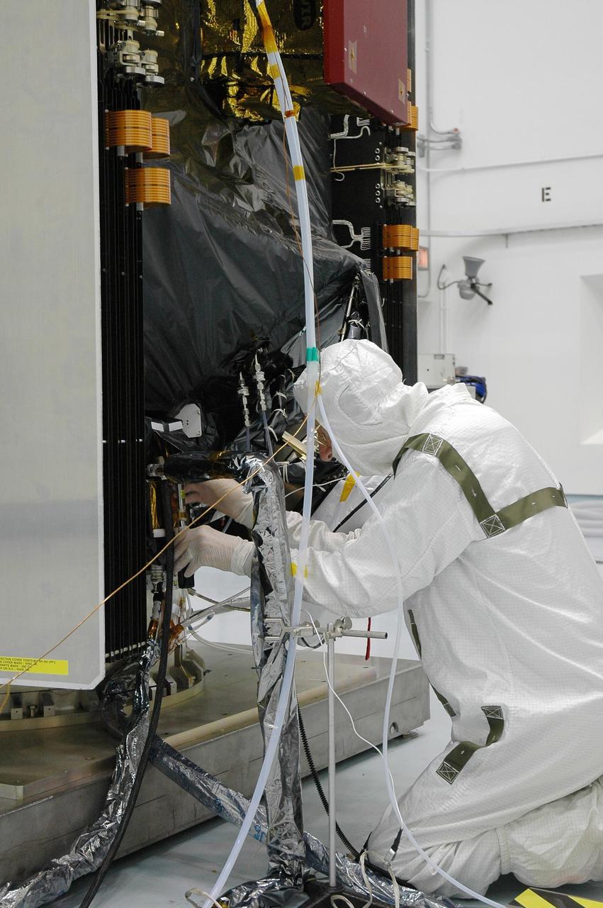 KENNEDY SPACE CENTER, FLA. --  At Astrotech's Hazardous Processing Facility, a technician checks the connections for loading the Dawn spacecraft with xenon gas for the ion propulsion system. Dawn's mission is to explore two of the asteroid belt's most intriguing and dissimilar occupants: asteroid Vesta and the dwarf planet Ceres. The Dawn spacecraft uses ion propulsion to get the additional velocity needed to reach Vesta once it leaves the Delta rocket. It also uses ion propulsion to spiral to lower altitudes on Vesta, to leave Vesta and cruise to Ceres and to spiral to a low-altitude orbit at Ceres. Ion propulsion makes efficient use of the onboard fuel by accelerating it to a velocity 10 times that of chemical rockets.  Dawn is scheduled to launch July 7aboard a Delta II rocket from Launch Complex 17-B at Cape Canaveral Air Force Station.   Photo credit: NASA/Jim Grossmann