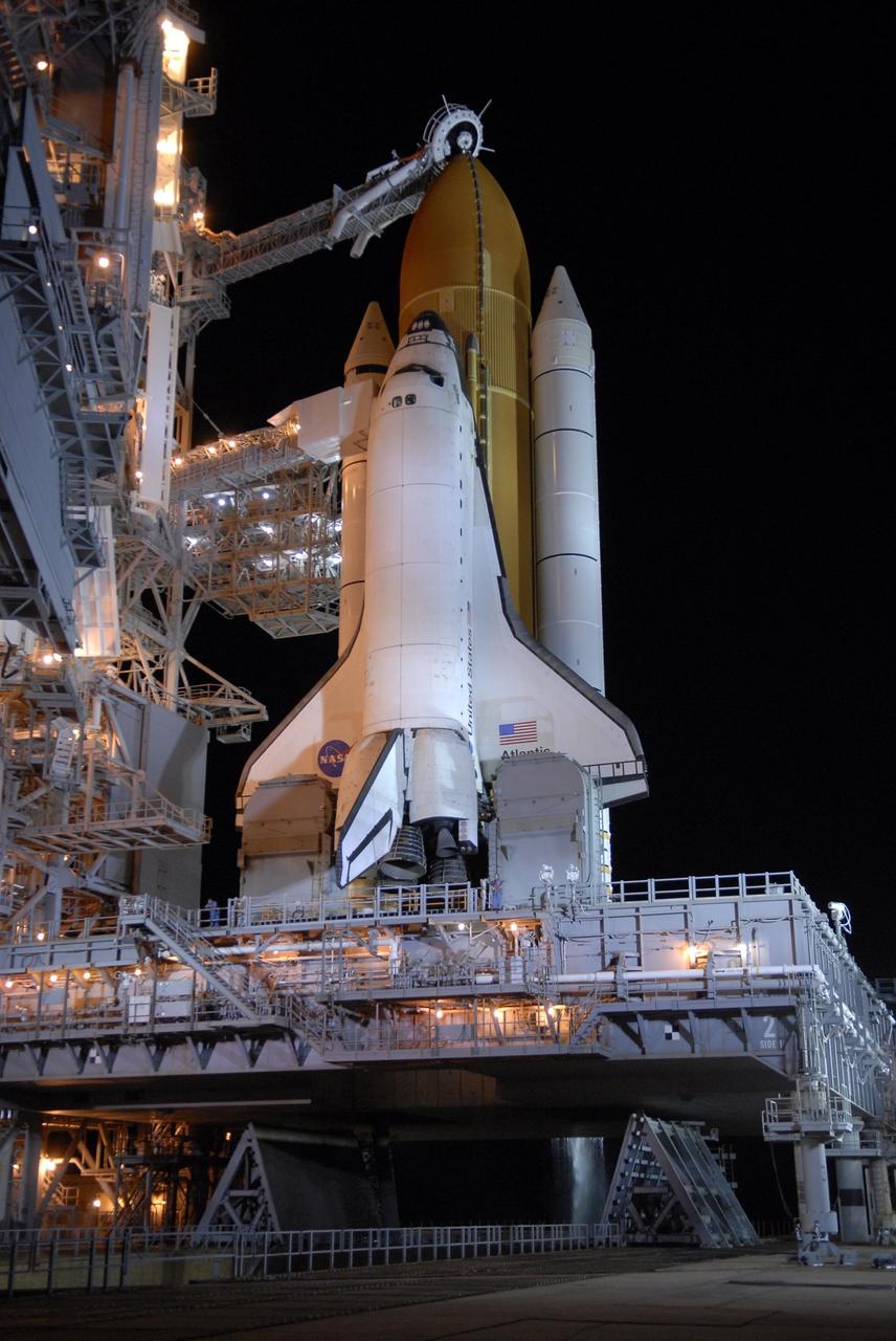 KENNEDY SPACE CENTER, FLA. --  After rollback of the rotating service structure, or RSS, on Launch Pad 39A, Space Shuttle Atlantis stands bathed in lights. Rollback is one of the milestones in preparation for the launch of mission STS-117 on June 8. Rollback started at 10:56 p.m. and was complete at 11:34 p.m EDT. The RSS provides protected access to the orbiter for changeout and servicing of payloads at the pad. The structure is supported by a rotating bridge that pivots about a vertical axis on the side of the pad's flame trench. The hinge column rests on the pad surface and is braced to the fixed service structure.  Support for the outer end of the bridge is provided by two eight-wheel, motor-driven trucks that move along circular twin rails installed flush with the pad surface. The track crosses the flame trench on a permanent bridge. The RSS is 102 feet long, 50 feet wide and 130 feet high. The structure has orbiter access platforms at five levels to provide access to the payload bay while the orbiter is being serviced in the RSS. Each platform has independent extendable planks that can be arranged to conform to a payload's configuration. This mission is the 118th shuttle flight and the 21st U.S. flight to the International Space Station and will deliver and install the S3/S4 truss segment, deploy a set of solar arrays and prepare them for operation.  Photo credit: NASA/Kim Shiflett