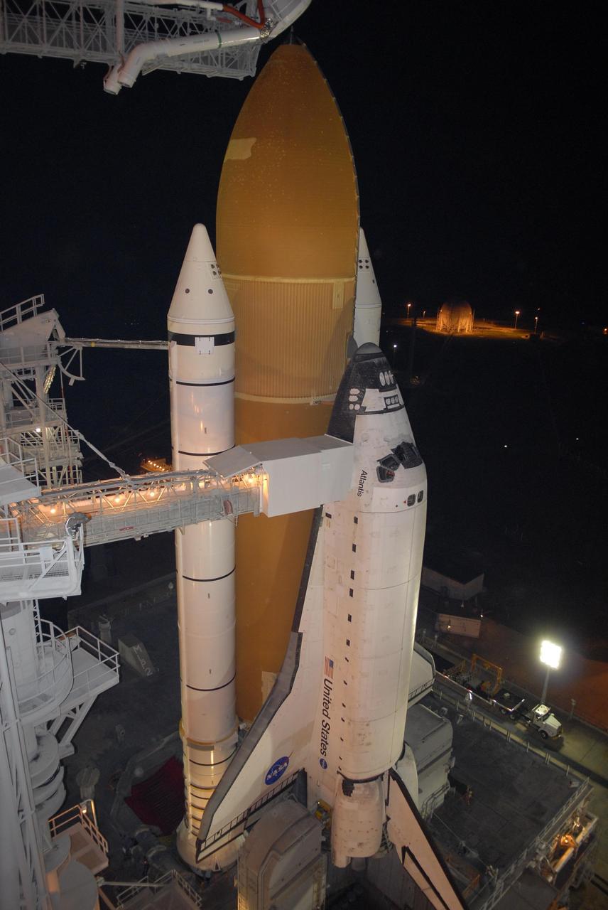 KENNEDY SPACE CENTER, FLA. --  Following rollback of the rotating service structure, or RSS, on Launch Pad 39A, Space Shuttle Atlantis stands bathed in lights atop a mobile launch platform. Rollback is one of the milestones in preparation for the launch of mission STS-117 on June 8. Rollback started at 10:56 p.m. and was complete at 11:34 p.m EDT. The RSS provides protected access to the orbiter for changeout and servicing of payloads at the pad. Connecting the RSS to the cockpit of the shuttle is the orbiter access arm with the White Room extended. The White Room provides access into the orbiter for the astronauts. This mission is the 118th shuttle flight and the 21st U.S. flight to the International Space Station and will deliver and install the S3/S4 truss segment, deploy a set of solar arrays and prepare them for operation. Photo credit: NASA/Kim Shiflett