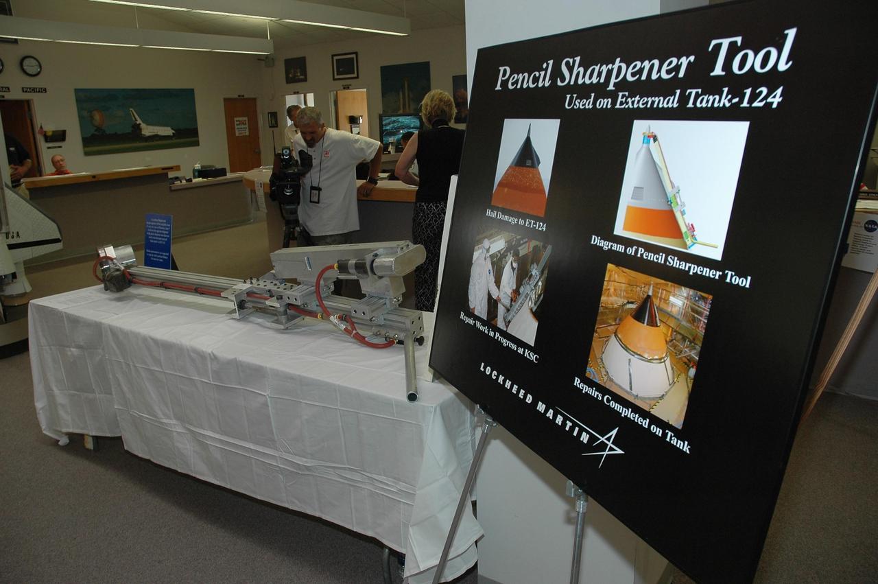KENNEDY SPACE CENTER, FLA. --  The "pencil sharpener" tool designed to trim the hand-sprayed foam repairs on the STS-117 external tank is on display for the media at the NASA News Center. This portable tool was designed in just 10 days specifically for this task by Lockheed Martin engineer Glenn Lapeyronnie at the Michoud external tank manufacturing facility in New Orleans. The pencil sharpener tool fits over the external tank nose cone spike at the top of the tank and extends down to where the hand-sprayed foam was used to repair the hail-damaged areas. The hail damage was incurred Feb. 28 while Space Shuttle Atlantis was on the launch pad for a March 15 launch.  The shuttle returned to the Vehicle Assembly Building so that repairs could be made.  Mission STS-117 is scheduled to launch at 7:38 p.m. EDT on June 8.   Photo credit: NASA/Jack Pfaller