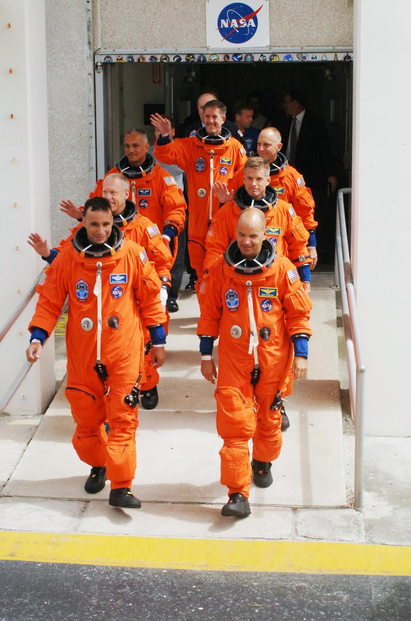 KENNEDY SPACE CENTER, FLA. -- The STS-117 crew members stride out of the Operations and Checkout Building as they head for the astrovan to take them to Launch Pad 39A. Leading the way are Pilot Lee Archambault (left) and Commander Frederick Sturckow. Behind them, left and right, are Mission Specialists Patrick Forrester and Steven Swanson, John "Danny" Olivas and astronaut Clayton Anderson, and James Reilly at the rear. Anderson is joining the Expedition 15 crew on the International Space Station; Flight Engineer Suni Williams will return to Earth in his place. Liftoff is scheduled for 7:38 p.m. today aboard Space Shuttle Atlantis. The shuttle is delivering a new segment to the starboard side of the International Space Station's backbone, known as the truss. Three spacewalks are planned to install the S3/S4 truss segment, deploy a set of solar arrays and prepare them for operation. STS-117 is the 118th space shuttle flight, the 21st flight to the station, the 28th flight for Atlantis and the first of four flights planned for 2007. Photo credit: NASA/Kim Shiflett