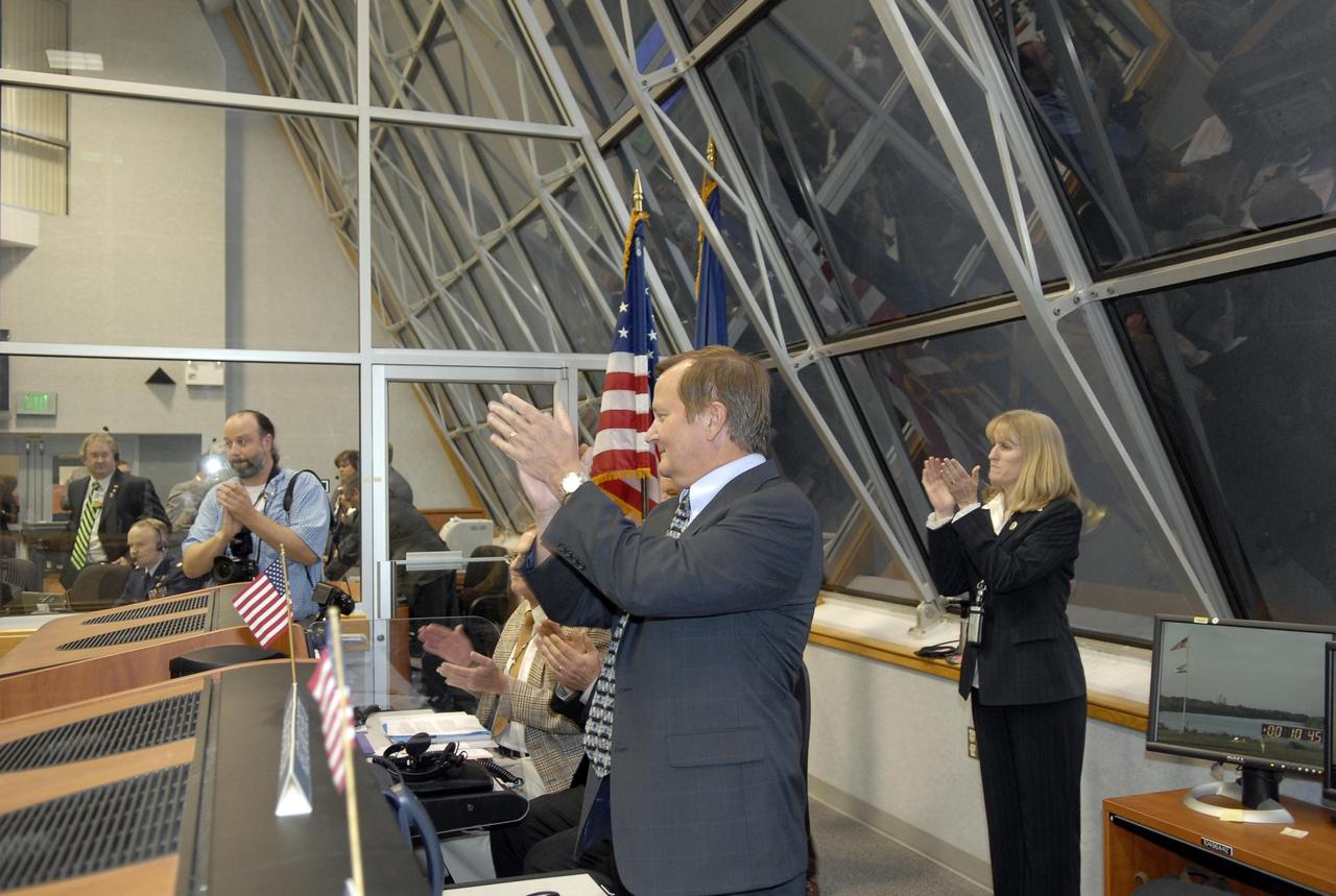 KENNEDY SPACE CENTER, FLA. -- In the Launch Control Center, Shuttle Launch Director Mike Leinbach applauds the team for a successful launch of Space Shuttle Atlantis on mission STS-117 to the International Space Station. At right, Angie Brewer, NASA flow director for Atlantis, also applauds the team. Liftoff from Launch Pad 39A was on-time at 7:38:04 p.m. EDT. The shuttle is delivering a new segment to the starboard side of the International Space Station's backbone, known as the truss. Three spacewalks are planned to install the S3/S4 truss segment, deploy a set of solar arrays and prepare them for operation. STS-117 is the 118th space shuttle flight, the 21st flight to the station, the 28th flight for Atlantis and the first of four flights planned for 2007. Photo credit: NASA/Kim Shiflett