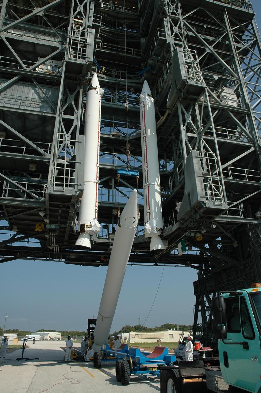 KENNEDY SPACE CENTER, FLA. -- A third solid rocket booster is raised off its transporter before being lifted into the mobile service tower on Launch Pad 17-B at Cape Canaveral Air Force Station.  The booster will join the others suspended in the tower to be mated to the Delta II first stage for launch of the Dawn spacecraft.  Dawn's goal is to characterize the conditions and processes of the solar system's earliest epoch 4.5 billion years ago by investigating in detail two of the largest asteroids, Ceres and Vesta. They reside between Mars and Jupiter in the asteroid belt.  Launch is targeted for July 7.  Photo credit: NASA/Jim Grossmann