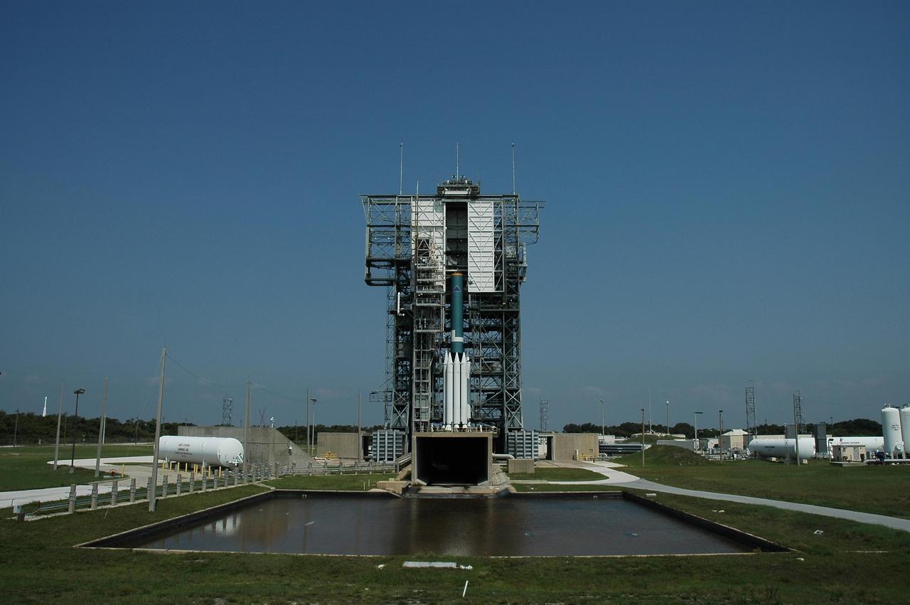 KENNEDY SPACE CENTER, FLA. --  On Launch Pad 17-B at Cape Canaveral Air Force Station, buildup of the Delta II first stage and solid rocket boosters for the Dawn spacecraft is seen.  Below the rocket is the flame trench, and in the foreground is the overflow pool.  Dawn's goal is to characterize the conditions and processes of the solar system's earliest epoch 4.5 billion years ago by investigating in detail two of the largest asteroids, Ceres and Vesta. They reside between Mars and Jupiter in the asteroid belt.  Launch is targeted for July 7.  Photo credit: NASA/Jim Grossmann