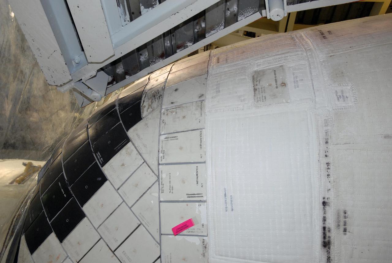KENNEDY SPACE CENTER, FLA. --  Another view of the area of orbiter Endeavour's orbital maneuvering system, or OMS, pod where the tear occurred on Atlantis during launch of mission STS-117 on June 8, 2007.  Repair is under consideration following testing at KSC and Houston.  The test articles each feature three tiles (Low Temperature Reusable Surface Insulation, or LRSI) affixed next to two FIB blankets, simulating the thermal protection system set-up on Atlantis' OMS pod in the vicinity of the in-flight anomaly.  These test articles were flown to Texas the morning of June 14.  The TPS team at KSC has also provided a total of 22 FIB samples for other testing and analysis.   Photo credit: NASA/Kim Shiflett