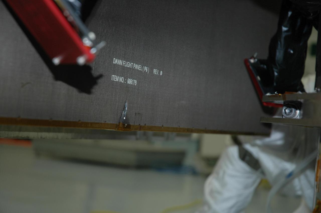 KENNEDY SPACE CENTER, FLA. -- On June 11, during a procedure to prepare the Dawn spacecraft for spin-balance testing, the back of a solar array panel was slightly damaged by a technician's tool. The size of the affected area is about 2.5 inches by 2 inches. The necessary minor repairs will be made during the coming weekend. There is no impact to the launch date of July 7. Dawn's goal is to characterize the conditions and processes of the solar system's earliest epoch 4.5 billion years ago by investigating in detail two of the largest asteroids, Ceres and Vesta. They reside between Mars and Jupiter in the asteroid belt. Photo courtesy of Orbital Sciences
