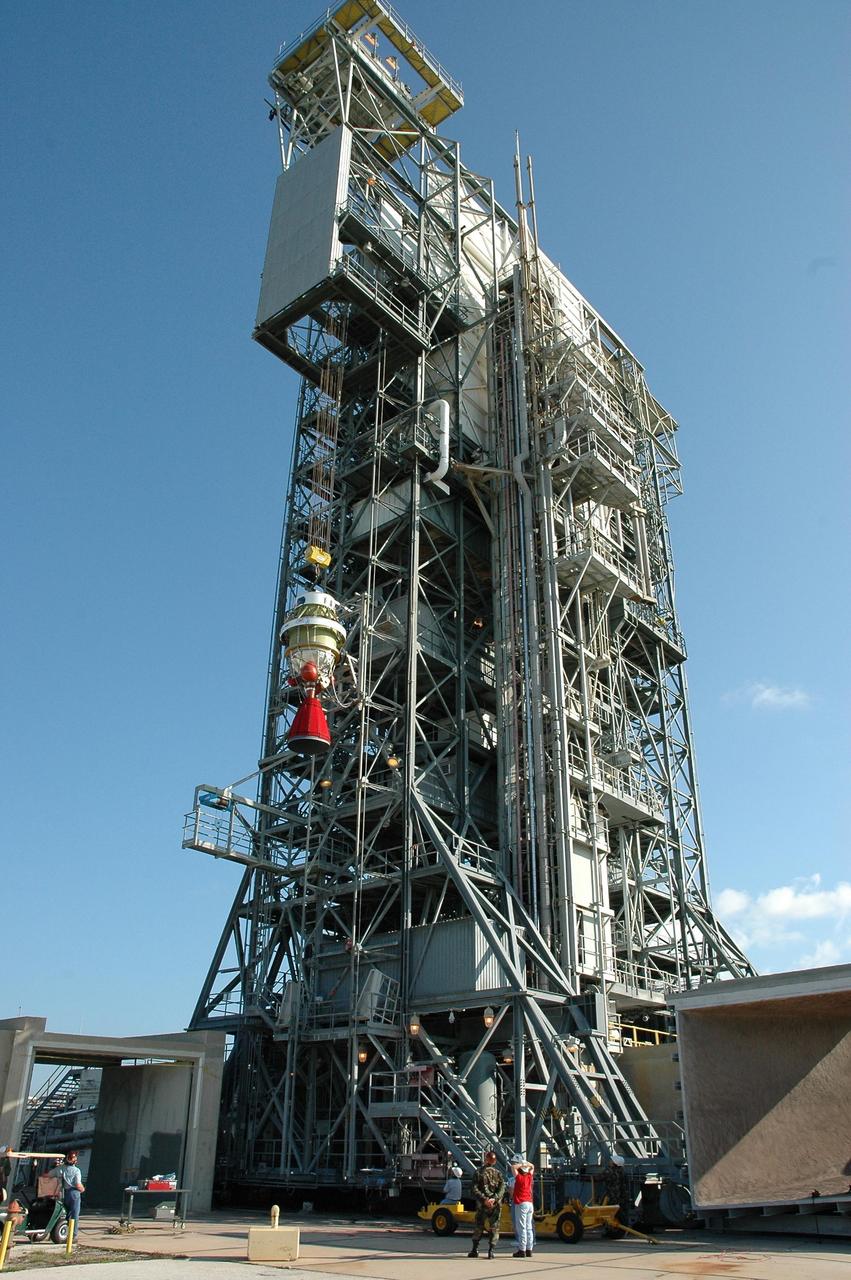 KENNEDY SPACE CENTER, FLA. -- The second stage of the Delta II launch vehicle for the Dawn spacecraft is lifted alongside the mobile service tower on Launch Pad 17-B at Cape Canaveral Air Force Station.  It will be mated with the first stage already in the tower. The Delta II-Heavy, manufactured by the United Launch Alliance, is scheduled to launch the Dawn spacecraft on its 4-year flight to the asteroid belt.  The Delta II-Heavy is the strongest rocket in the Delta II class. It will use three stages and nine solid-fueled booster rockets to propel Dawn on its way. A 9.5-foot payload fairing will protect the spacecraft from the heat and stresses of launch. Dawn's goal is to characterize the conditions and processes of the solar system's earliest epoch by investigating in detail the largest protoplanets that have remained intact since their formations: asteroid Vesta and the dwarf planet Ceres.  They reside in the extensive zone between Mars and Jupiter together with many other smaller bodies, called the asteroid belt.  Dawn is scheduled to launch July 7.  Photo credit: NASA/Jack Pfaller