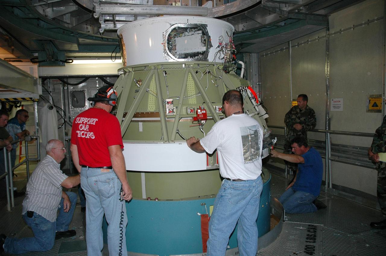 KENNEDY SPACE CENTER, FLA. --  On Launch Pad 17-B at Cape Canaveral Air Force Station, workers maneuver the second stage of the Delta II launch vehicle onto the first stage for mating.   The Delta II-Heavy, manufactured by the United Launch Alliance, is scheduled to launch the Dawn spacecraft on its 4-year flight to the asteroid belt.  The Delta II-Heavy is the strongest rocket in the Delta II class. It will use three stages and nine solid-fueled booster rockets to propel Dawn on its way. A 9.5-foot payload fairing will protect the spacecraft from the heat and stresses of launch. Dawn's goal is to characterize the conditions and processes of the solar system's earliest epoch by investigating in detail the largest protoplanets that have remained intact since their formations: asteroid Vesta and the dwarf planet Ceres.  They reside in the extensive zone between Mars and Jupiter together with many other smaller bodies, called the asteroid belt.  Dawn is scheduled to launch July 7.  Photo credit: NASA/Jack Pfaller