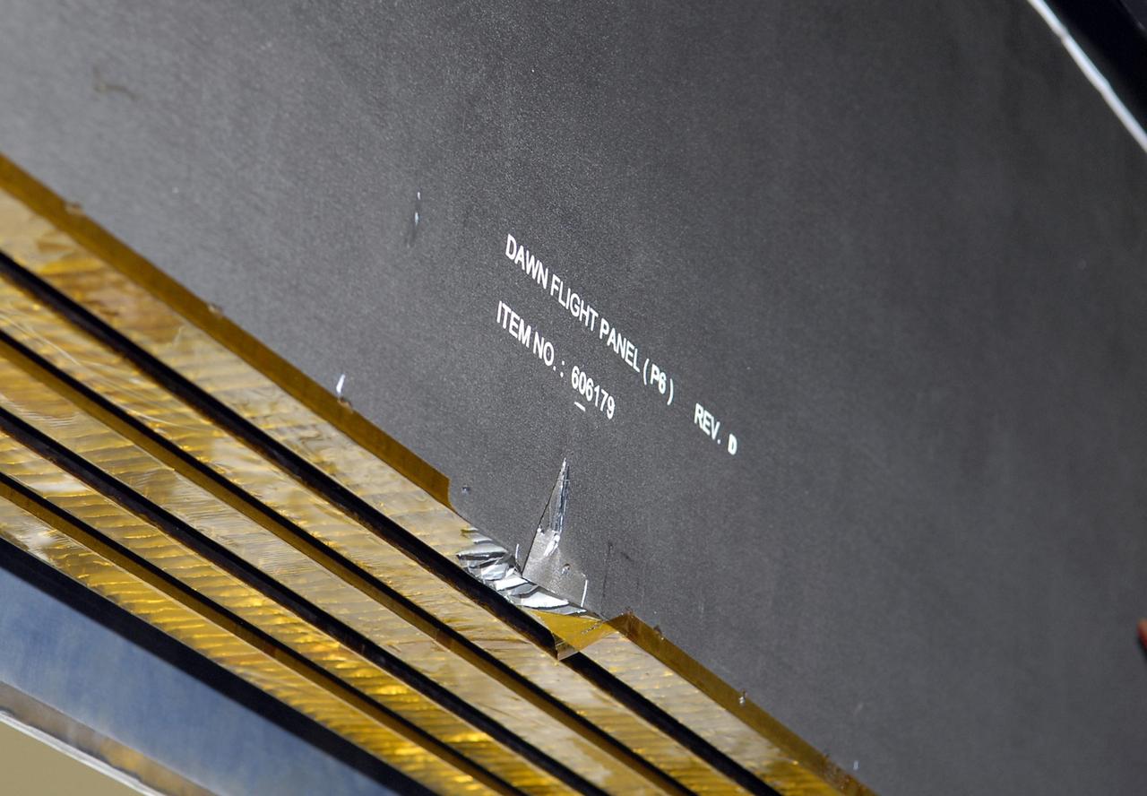 KENNEDY SPACE CENTER, FLA. -- This closeup shows the slight damage done by a technician's tool to the back of a solar array panel on June 11 during a procedure to prepare the Dawn spacecraft for spin-balance testing. Dawn's goal is to characterize the conditions and processes of the solar system's earliest epoch by investigating in detail the largest protoplanets that have remained intact since their formations: asteroid Vesta and the dwarf planet Ceres. They reside in the extensive zone between Mars and Jupiter together with many other smaller bodies, called the asteroid belt. Dawn is scheduled to launch July 7. Photo credit: NASA/Kim Shiflett