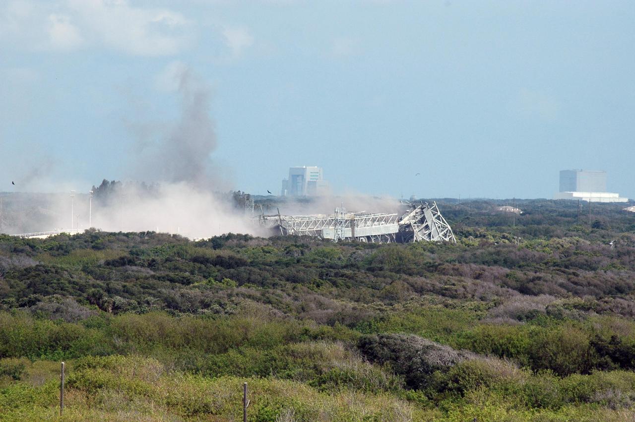 KENNEDY SPACE CENTER, FLA. --   Smoke and dust rising from the ground of Space Launch Complex 36 on Cape Canaveral Air Force Station signifies the destruction of the 209-foot-tall mobile service tower on Pad 39-A.  The tower is one of two that were identified for demolition.  The old towers are being toppled as part of the ongoing project to demolish the historic site to prevent corrosion from becoming a safety concern.   A majority of the steel will be recycled and the rest will be taken to the landfill at CCAFS.  Complex 36 was the birthplace of NASA's planetary launch program.  It was built for the Atlas/Centaur development program and was operated under NASA's sponsorship until the late 1980s. Complex 36 hosted many historic missions over the years including Surveyor that landed on the moon and Mariner that orbited Mars and included one to Mercury.  Two of the most historic launches were the Pioneer 10 and 11 space probes that were launched to Jupiter and are now outside of the solar system in interstellar space.  Also, the historic Pioneer Venus spacecraft included an orbiter and a set of probes that were dispatched to the surface.  While Launch Complex 36 is gone, the Atlas/Centaur rocket continues to be launched as the Atlas V from Complex 41. Photo credit: NASA/Charisse Nahser