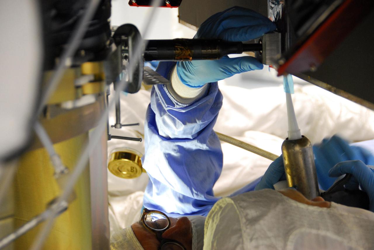 KENNEDY SPACE CENTER, FLA. -- At Astrotech, an engineer from Dutch Space is making repairs on the slight damage done by a technician's tool to the back of a solar array panel of the Dawn spacecraft on June 11 during a procedure to prepare Dawn for spin-balance testing. The size of the affected area is about 2.5 inches by 2 inches. There is no impact to the launch date of July 7. Dawn's goal is to characterize the conditions and processes of the solar system's earliest epoch 4.5 billion years ago by investigating in detail two of the largest asteroids, Ceres and Vesta. They reside between Mars and Jupiter in the asteroid belt. Photo credit: NASA/George Shelton