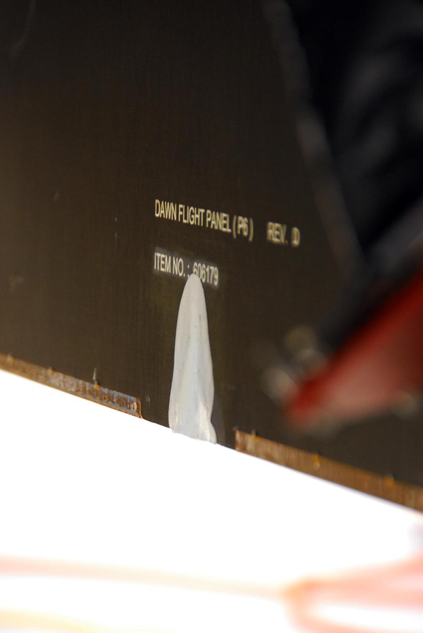 KENNEDY SPACE CENTER, FLA. -- Seen here is the area of damage under repair on the solar array panel on the Dawn spacecraft. The damage occurred at Astrotech on June 11 from a technician's tool during a procedure to prepare Dawn for spin-balance testing. The size of the affected area is about 2.5 inches by 2 inches. There is no impact to the launch date of July 7. Dawn's goal is to characterize the conditions and processes of the solar system's earliest epoch 4.5 billion years ago by investigating in detail two of the largest asteroids, Ceres and Vesta. They reside between Mars and Jupiter in the asteroid belt. Photo credit: NASA/George Shelton