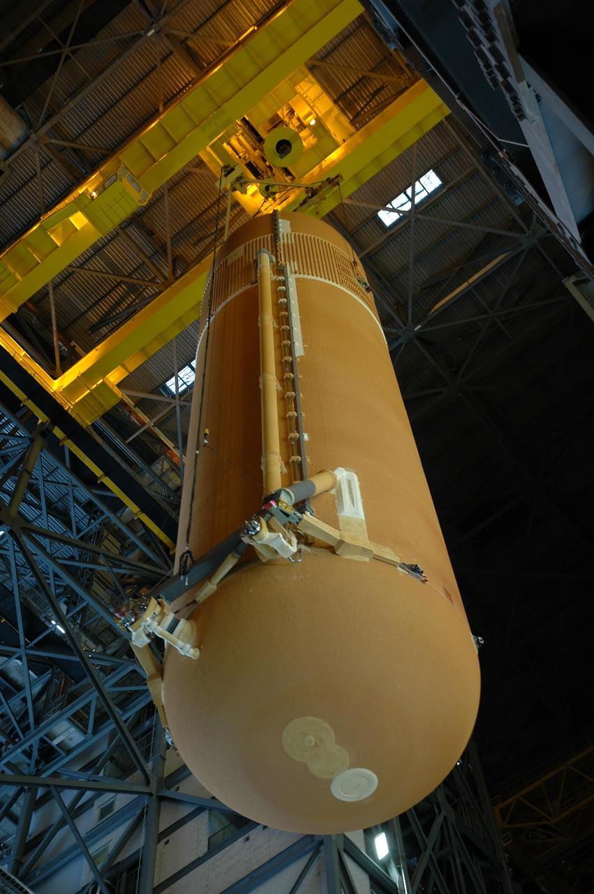 KENNEDY SPACE CENTER, FLA. --   Inside the Vehicle Assembly Building, the external tank for Endeavour is being lowered toward the mobile launcher platform for mating with the solid rocket boosters. Endeavour is currently targeted for rollover to the VAB July 5.  On the lower end of the tank is seen the bipod fittings that connect the external tank to the orbiter through the shuttle's two forward attachment struts.  Endeavour is the designated orbiter for mission STS-118, targeted for launch on Aug. 9 to the International Space Station. The mission will continue space station construction by delivering a third starboard truss segment, S5, as well as carrying the external stowage platform 3.  Photo credit: NASA/Amanda Diller