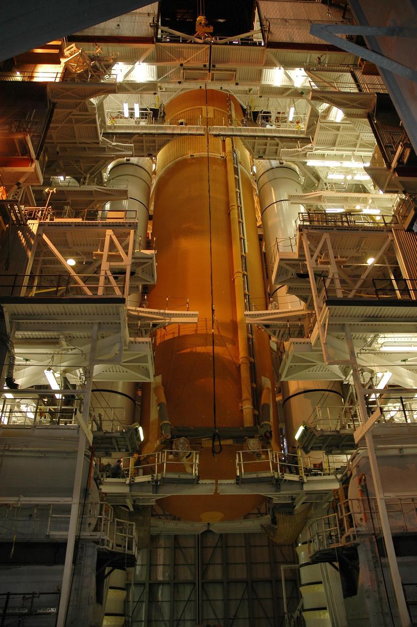 KENNEDY SPACE CENTER, FLA. -- Inside the Vehicle Assembly Building, the external tank for Endeavour is lowered between the solid rocket boosters toward the mobile launcher platform below.  Endeavour is currently  targeted for rollover to the VAB July 5. Endeavour is the designated orbiter for mission STS-118, targeted for launch on Aug. 9 to the International Space Station. The mission will continue space station construction by delivering a third starboard truss segment, S5, as well as carrying the external stowage platform 3.  Photo credit: NASA/Amanda Diller