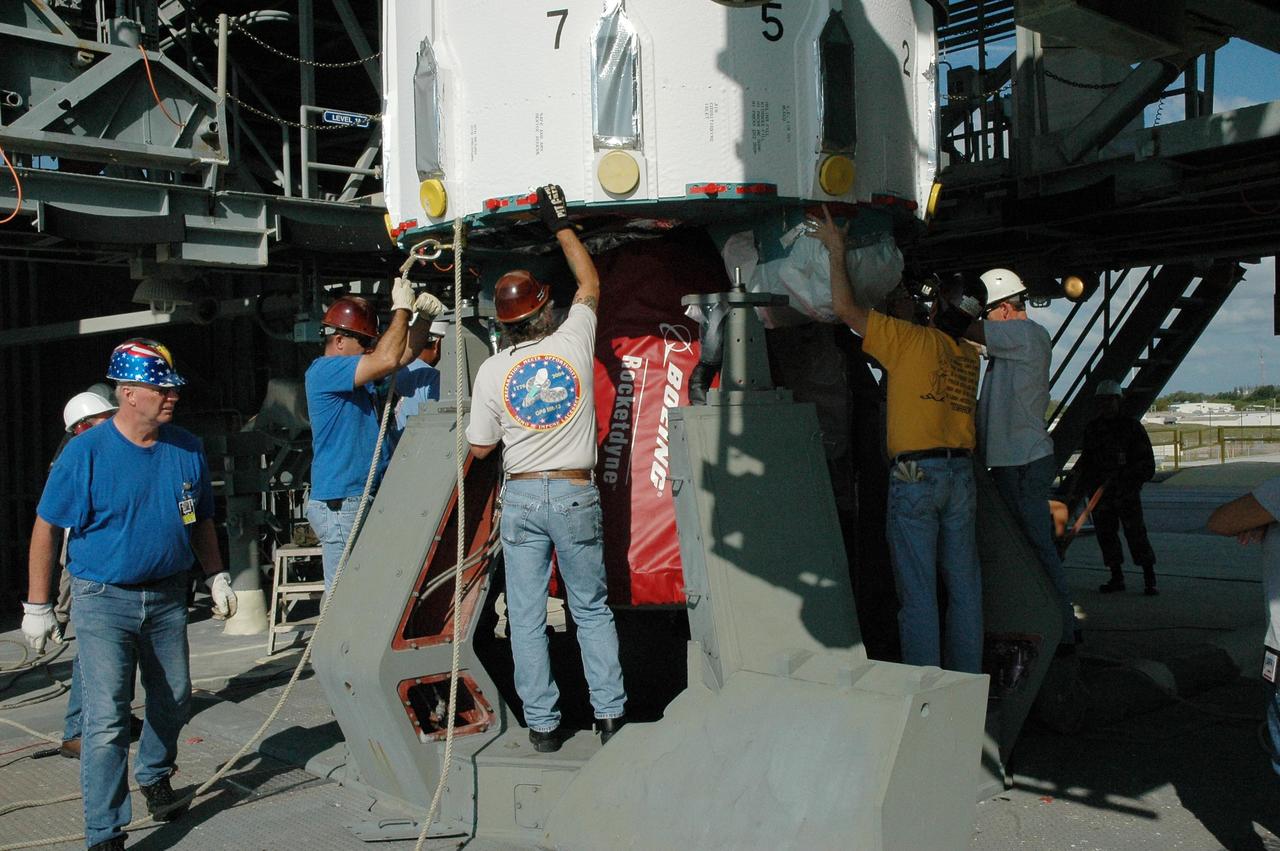 KENNEDY SPACE CENTER, FLA. -- On Launch Pad 17-A at Cape Canaveral Air Force Station, workers prepare the first stage of a Delta II rocket to be lifted up into the mobile service tower. The rocket is the launch vehicle for the Phoenix spacecraft, targeted for launch on Aug. 3 heading for Mars. Phoenix will land in icy soils near the north polar permanent ice cap of Mars and explore the history of the water in these soils and any associated rocks, while monitoring polar climate. Landing on Mars is planned in May 2008 on arctic ground where a mission currently in orbit, Mars Odyssey, has detected high concentrations of ice just beneath the top layer of soil. Photo credit: NASA/Amanda Diller