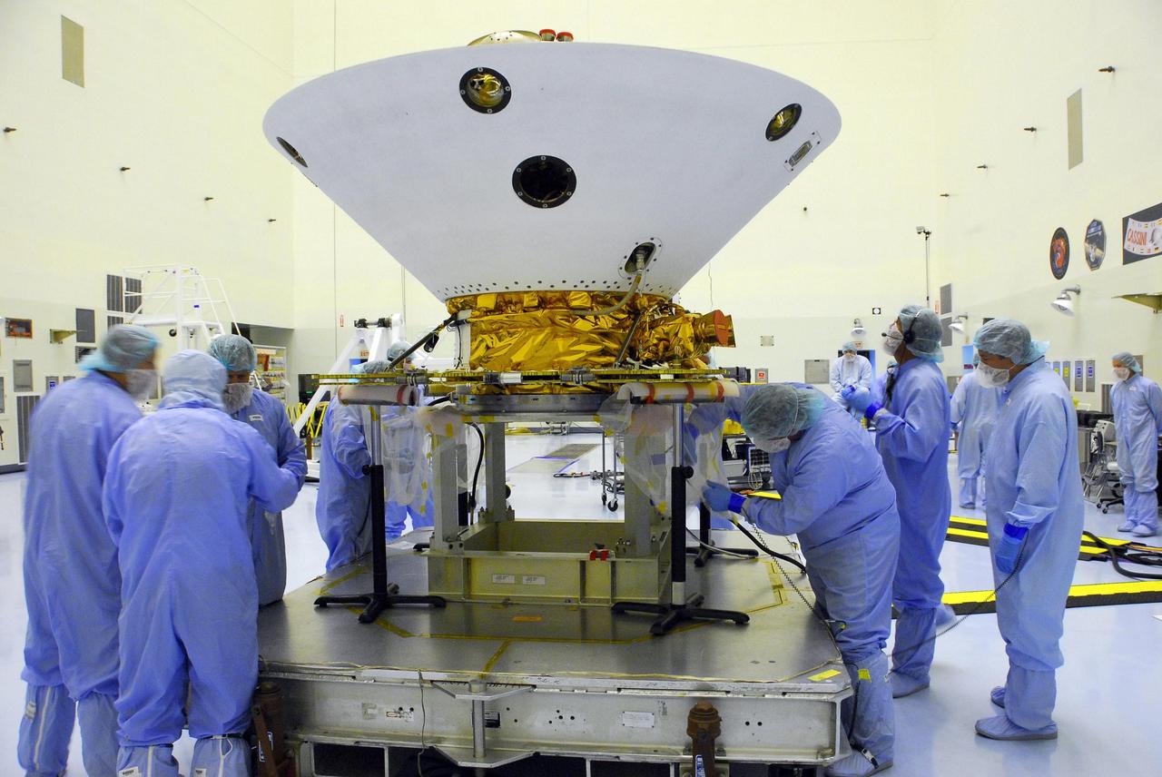 KENNEDY SPACE CENTER, FLA. -- In the Payload Hazardous Servicing Facility at Cape Canaveral Air Force Station, workers retrieve the springs and bolts from the test firing on the Phoenix Mars Lander spacecraft to deploy the solar panels. The deployment of the panels is part of the pre-launch testing under way. Phoenix will land in icy soils near the north polar permanent ice cap of Mars and explore the history of the water in these soils and any associated rocks, while monitoring polar climate. Landing on Mars is planned in May 2008 on arctic ground where a mission currently in orbit, Mars Odyssey, has detected high concentrations of ice just beneath the top layer of soil. Phoenix is scheduled to launch Aug. 3. Photo credit: NASA/George Shelton
