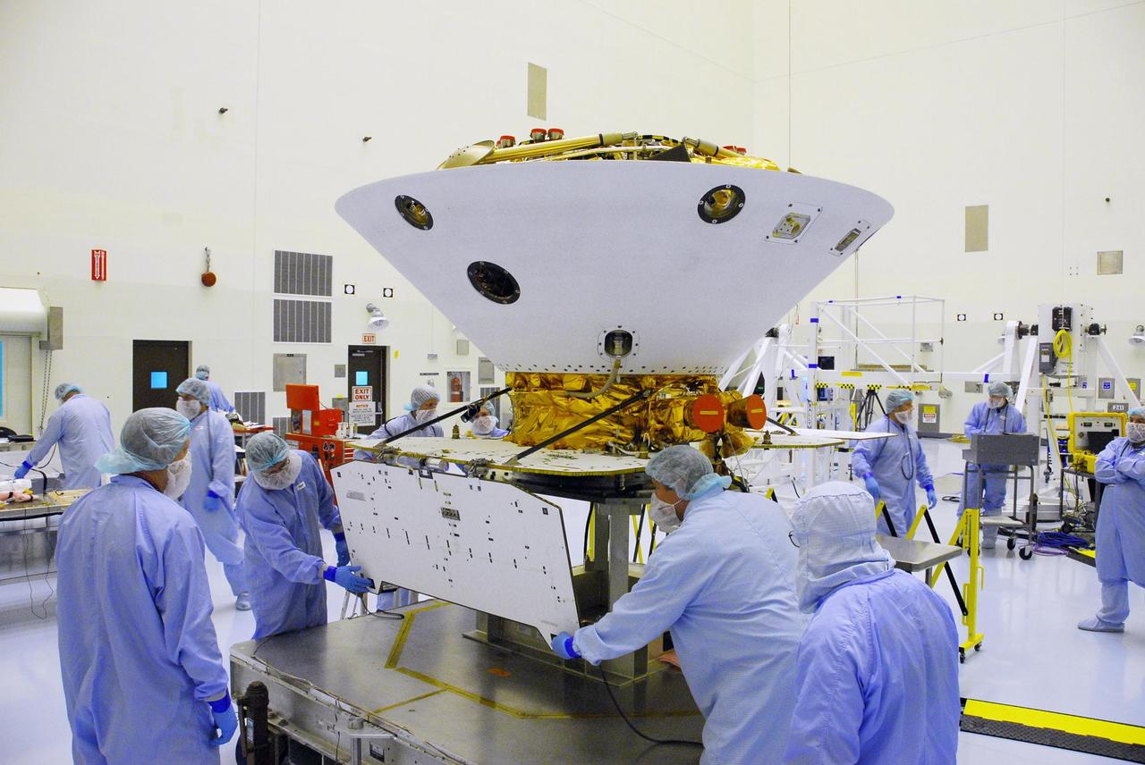 KENNEDY SPACE CENTER, FLA. -- In the Payload Hazardous Servicing Facility at Cape Canaveral Air Force Station, workers begin unfolding the solar array panels on the Phoenix Mars Lander spacecraft. The deployment of the panels is part of the pre-launch testing under way. Phoenix will land in icy soils near the north polar permanent ice cap of Mars and explore the history of the water in these soils and any associated rocks, while monitoring polar climate. Landing on Mars is planned in May 2008 on arctic ground where a mission currently in orbit, Mars Odyssey, has detected high concentrations of ice just beneath the top layer of soil. Phoenix is scheduled to launch Aug. 3. Photo credit: NASA/George Shelton
