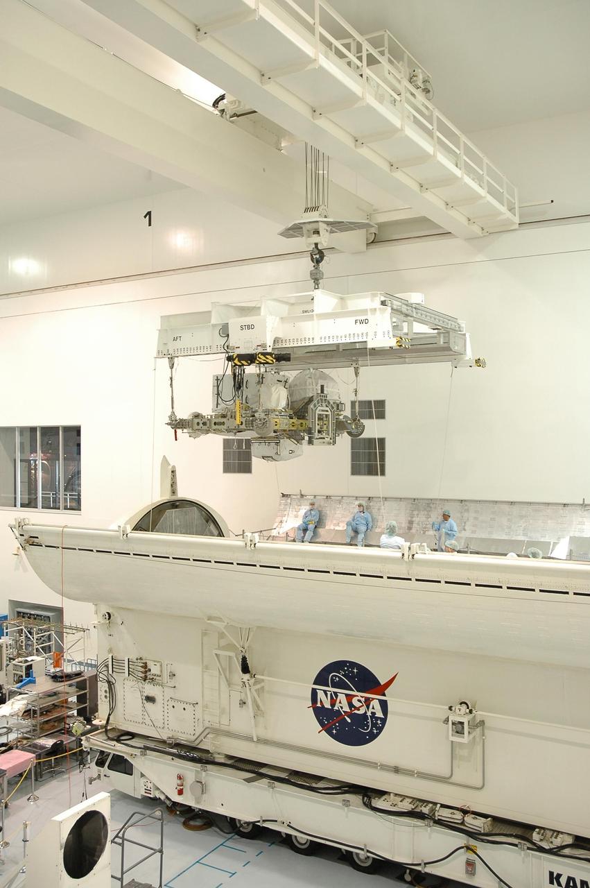 KENNEDY SPACE CENTER, FLA. -- In the Space Station Processing Facility, an overhead crane lowers the external stowage platform 3 into the payload canister. The platform is part of the payload on mission STS-118 and will be loaded into Space Shuttle Endeavour's payload bay at the pad. Endeavour is targeted for launch on Aug. 9 to the International Space Station. The mission will continue space station construction by delivering a third starboard truss segment, S5, as well as carrying the external stowage platform 3. Photo credit: NASA/Jim Grossmann