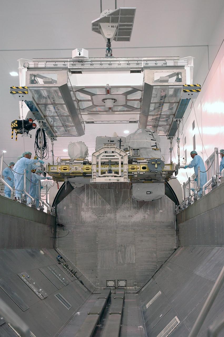KENNEDY SPACE CENTER, FLA. -- In the Space Station Processing Facility, workers maneuver an overhead crane lowering the external stowage platform 3 into the payload canister below. The platform is part of the payload on mission STS-118 and will be loaded into Space Shuttle Endeavour's payload bay at the pad. Endeavour is targeted for launch on Aug. 9 to the International Space Station. The mission will continue space station construction by delivering a third starboard truss segment, S5, as well as carrying the external stowage platform 3. Photo credit: NASA/Jim Grossmann
