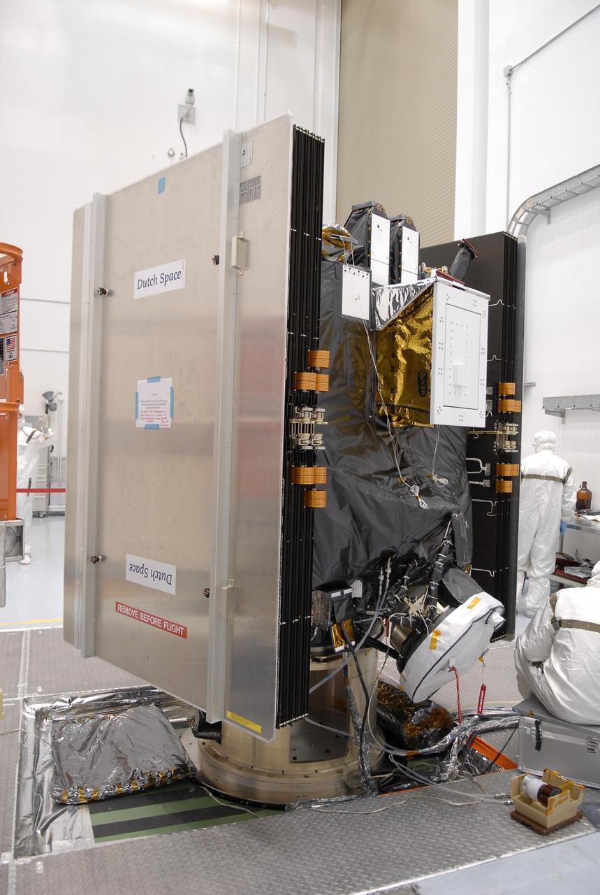 KENNEDY SPACE CENTER, FLA. -- At Astrotech, the Dawn spacecraft is on display for a media showing. On each side are the folded solar array panels. The "box" in the upper center is the visual and infrared mapping spectrometer, which is designed to measure how much radiation of different "colors" is reflected or emitted by an object. At the bottom, under cover, is one of the ion propulsion thrusters. Dawn's goal is to characterize the conditions and processes of the solar system's earliest epoch by investigating in detail the largest protoplanets that have remained intact since their formations: asteroid Vesta and the dwarf planet Ceres. They reside in the extensive zone between Mars and Jupiter together with many other smaller bodies, called the asteroid belt. Photo credit: NASA/Kim Shiflett