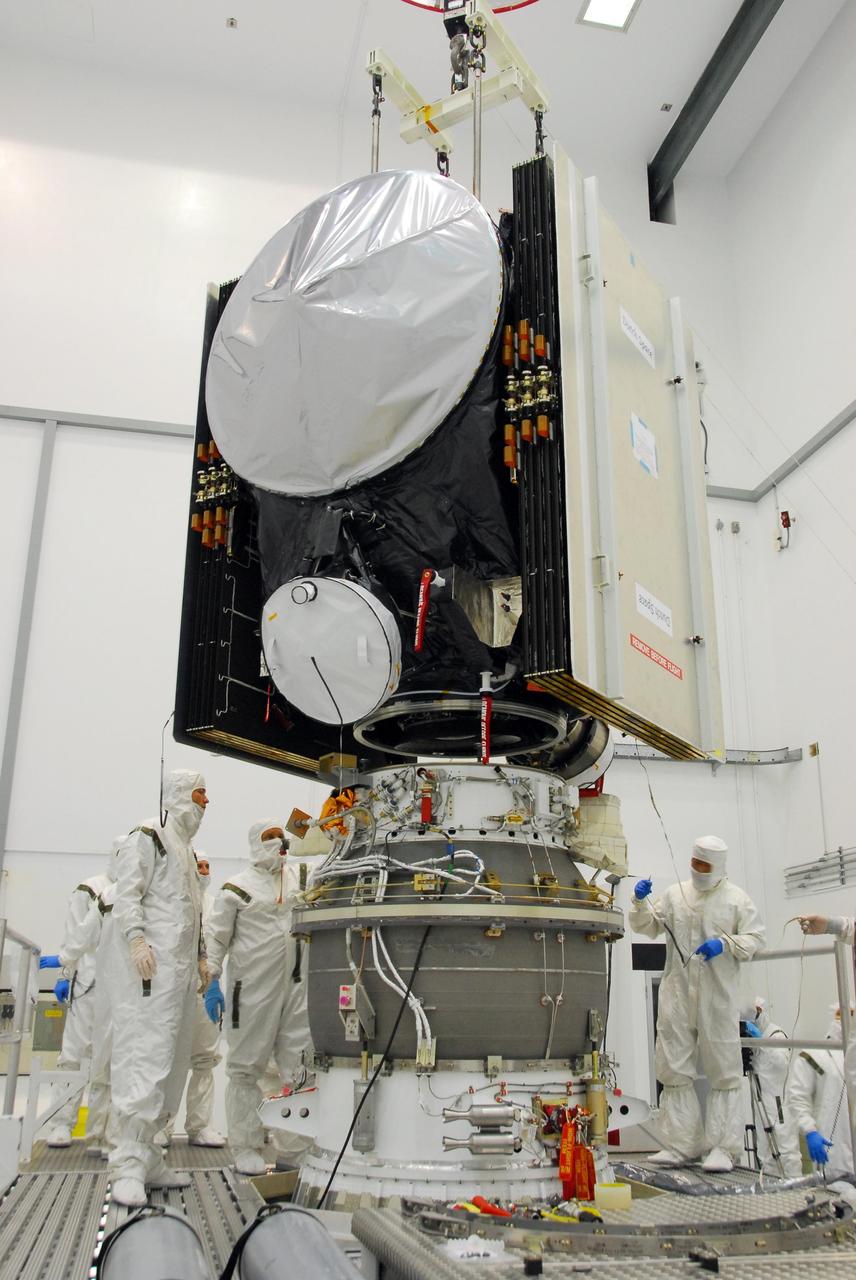 KENNEDY SPACE CENTER, FLA. -- At Astrotech, workers check the progress of the Dawn spacecraft being lowered toward the upper stage booster below. The two elements will be mated for launch. Dawn's goal is to characterize the conditions and processes of the solar system's earliest epoch by investigating in detail the largest protoplanets that have remained intact since their formations: asteroid Vesta and the dwarf planet Ceres. They reside in the extensive zone between Mars and Jupiter together with many other smaller bodies, called the asteroid belt. Photo credit: NASA/George Shelton