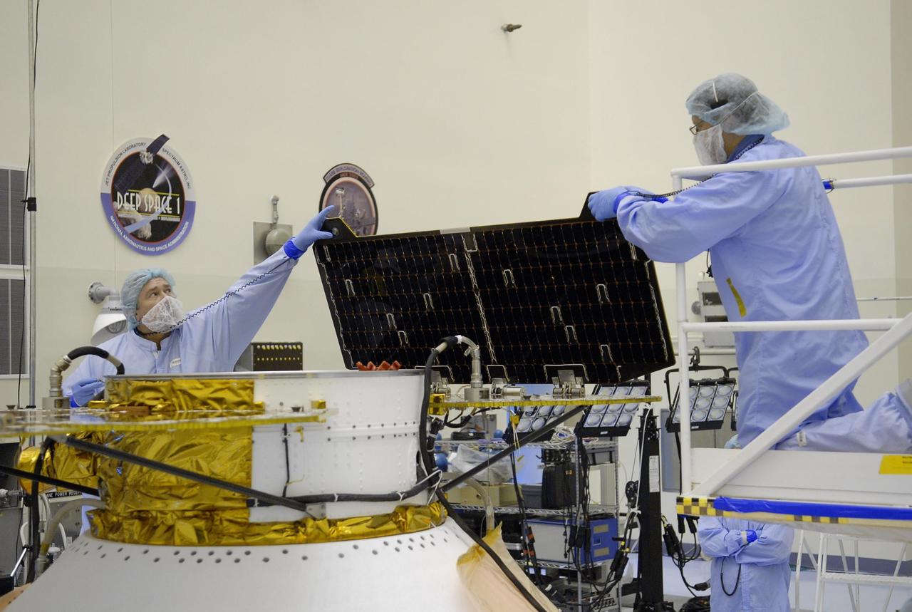 KENNEDY SPACE CENTER, FLA. -- After illumination testing of the solar array panels, technicians begin stowing the panels on the Phoenix Mars Lander spacecraft. The Phoenix will be launched toward Mars to land in icy soils near the planet's north polar permanent ice cap. It will explore the history of the water in these soils and any associated rocks, while monitoring polar climate. Landing on Mars is planned in May 2008 on arctic ground where a mission currently in orbit, Mars Odyssey, has detected high concentrations of ice just beneath the top layer of soil. Phoenix is scheduled to launch Aug. 3 from Pad 17-A at Cape Canaveral Air Force Station . Photo credit: NASA/Kim Shiflett