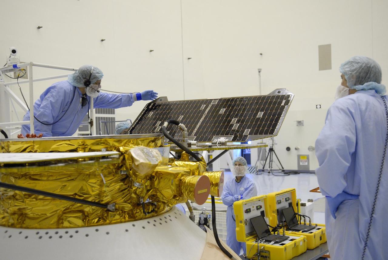 KENNEDY SPACE CENTER, FLA. -- After illumination testing of the solar array panels, technicians begin stowing the panels on the Phoenix Mars Lander spacecraft. The Phoenix will be launched toward Mars to land in icy soils near the planet's north polar permanent ice cap. It will explore the history of the water in these soils and any associated rocks, while monitoring polar climate. Landing on Mars is planned in May 2008 on arctic ground where a mission currently in orbit, Mars Odyssey, has detected high concentrations of ice just beneath the top layer of soil. Phoenix is scheduled to launch Aug. 3 from Pad 17-A at Cape Canaveral Air Force Station . Photo credit: NASA/Kim Shiflett