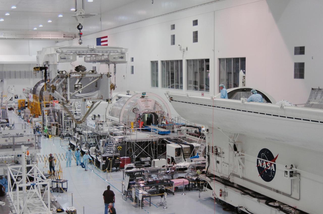 KENNEDY SPACE CENTER, FLA. -- In the Space Station Processing Facility, the overhead crane moves the S5 integrated truss across other modules toward the payload canister, at right. The S5 will join the external stowage platform 3 (ESP3) already in the canister. Endeavour is targeted for launch on Aug. 9 to the International Space Station. The mission will continue space station construction by delivering the third starboard truss segment, as well as carrying the ESP3 and the SPACEHAB module. Photo credit: NASA/Dimitri Gerondidakis