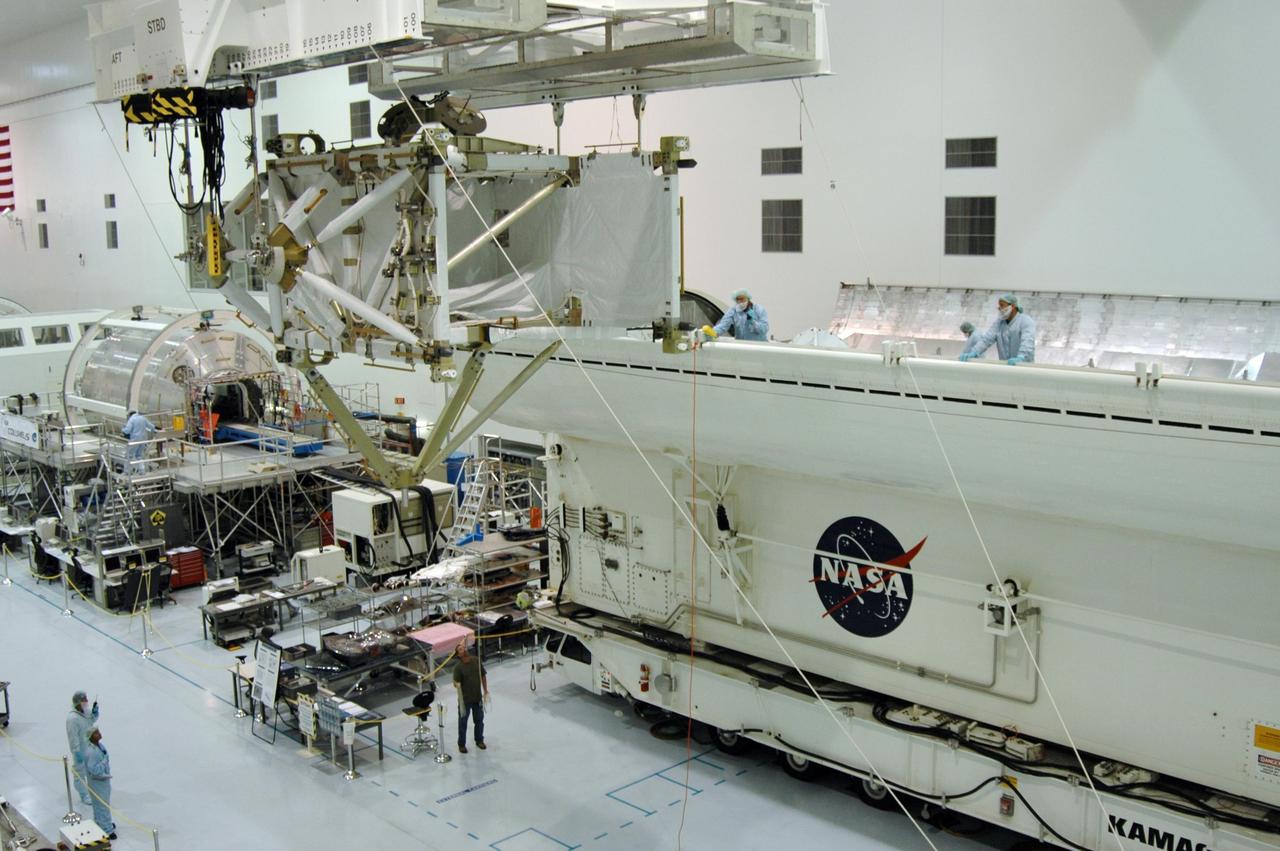 KENNEDY SPACE CENTER, FLA. -- In the Space Station Processing Facility, the overhead crane moves the S5 integrated truss across other modules toward the payload canister, at right. The S5 will join the external stowage platform 3 (ESP3) already in the canister. Endeavour is targeted for launch on Aug. 9 to the International Space Station. The mission will continue space station construction by delivering the third starboard truss segment, as well as carrying the ESP3 and the SPACEHAB module. Photo credit: NASA/Dimitri Gerondidakis