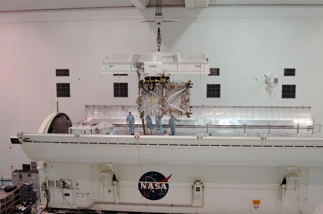 KENNEDY SPACE CENTER, FLA. -- In the Space Station Processing Facility, the overhead crane lowers the S5 integrated truss toward the payload canister. The external stowage platform 3 (ESP3) is already in the canister, at left. Endeavour is targeted for launch on Aug. 9 to the International Space Station. The mission will continue space station construction by delivering the third starboard truss segment, as well as carrying the ESP3 and the SPACEHAB module. Photo credit: NASA/Dimitri Gerondidakis