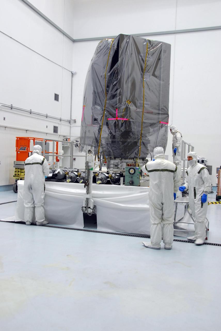 KENNEDY SPACE CENTER, FLA. --  At Astrotech, the Dawn spacecraft has been wrapped with a protective cover before it is enclosed in a canister.  Dawn will be transported to Launch Pad 17-B and lifted into the mobile service tower for mating with the Delta II launch vehicle.  The Delta II-Heavy, manufactured by the United Launch Alliance, is scheduled to launch the Dawn spacecraft on its 4-year flight to the asteroid belt.  The Delta II-Heavy will use three stages and nine solid-fueled booster rockets to propel Dawn on its way. A 9.5-foot payload fairing will protect the spacecraft from the heat and stresses of launch. Dawn's goal is to characterize the conditions and processes of the solar system's earliest epoch by investigating in detail the largest protoplanets that have remained intact since their formations: asteroid Vesta and the dwarf planet Ceres.  They reside in the extensive zone between Mars and Jupiter together with many other smaller bodies, called the asteroid belt.  Dawn is scheduled to launch July 7.    Photo credit: NASA/George Shelton
