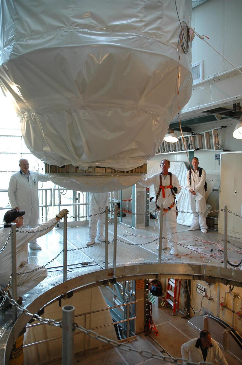 KENNEDY SPACE CENTER, FLA. -- At the top of Launch Pad 17-B, at Cape Canaveral Air Force Station, workers help to guide NASA’s Dawn spacecraft into position for stacking with the Delta II launch vehicle. Launch is scheduled for July 7. Dawn is the ninth mission in NASA's Discovery Program. The spacecraft will be the first to orbit two planetary bodies, asteroid Vesta and dwarf planet Ceres, during a single mission. Vesta and Ceres lie in the asteroid belt between Mars and Jupiter. It is also NASA’s first purely scientific mission powered by three solar electric ion propulsion engines. Photo credit: NASA/Troy Cryder.