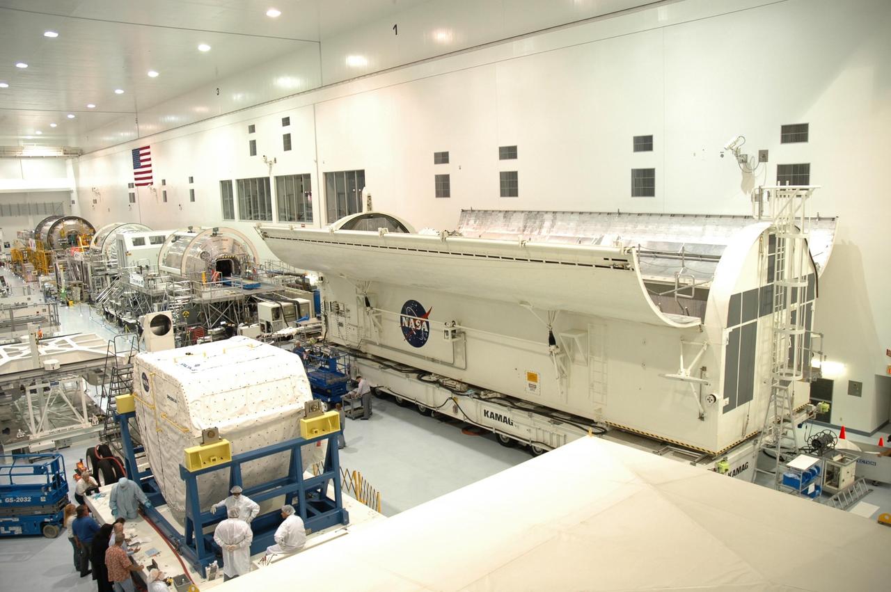 KENNEDY SPACE CENTER, FLA. -- At lower left, in the Space Station Processing Facility, the Spacehab module is prepared for its move to the payload canister at right. The module is part of the payload on mission STS-118 and will be loaded into Space Shuttle Endeavour's payload bay at the pad. Endeavour is targeted for launch on Aug. 9 to the International Space Station. The mission will continue space station construction by delivering a third starboard truss segment, S5, as well as carrying the external stowage platform 3 and Spacehab module. Photo credit: NASA/Jim Grossmann