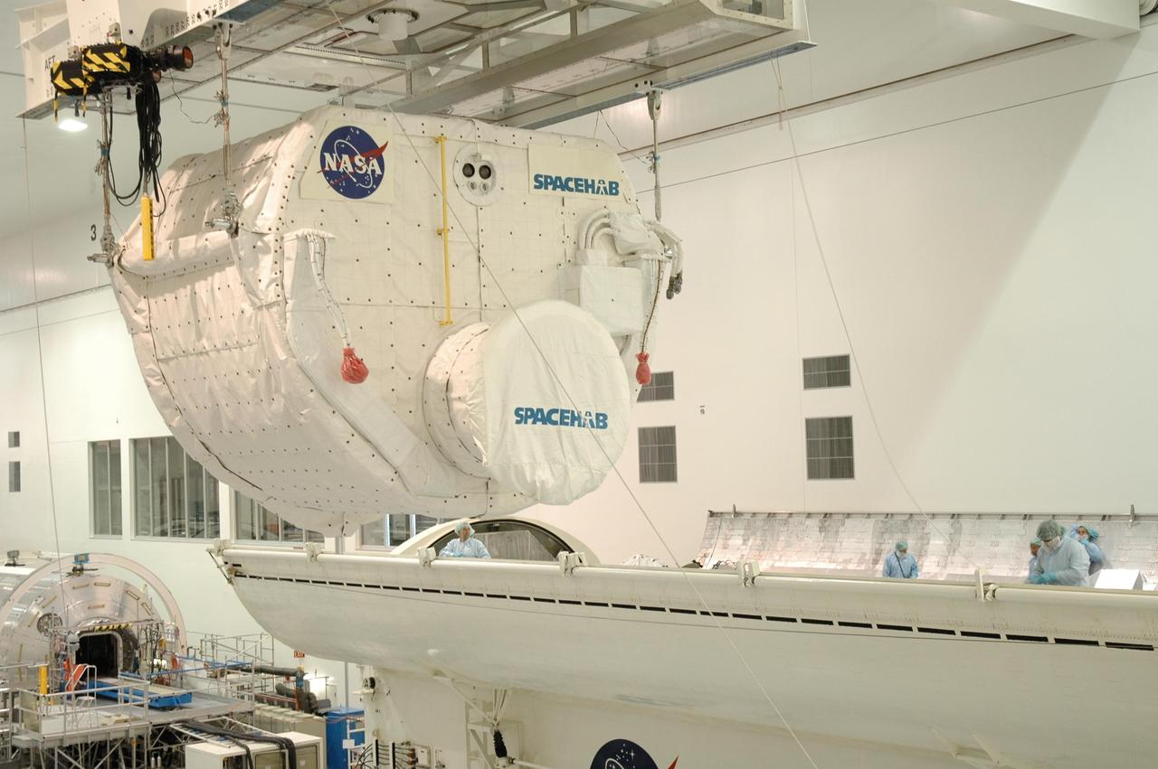 KENNEDY SPACE CENTER, FLA. -- In the Space Station Processing Facility, an overhead crane carries the Spacehab module to the payload canister. The module is part of the payload on mission STS-118 and will be loaded into Space Shuttle Endeavour's payload bay at the pad. Endeavour is targeted for launch on Aug. 9 to the International Space Station. The mission will continue space station construction by delivering a third starboard truss segment, S5, as well as carrying the external stowage platform 3 and Spacehab module. Photo credit: NASA/Jim Grossmann