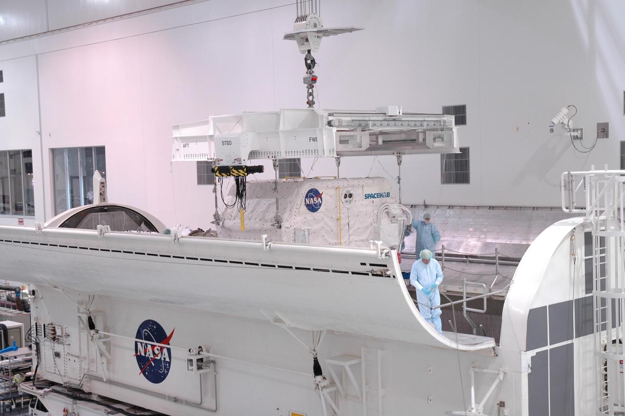 KENNEDY SPACE CENTER, FLA. -- In the Space Station Processing Facility, an overhead crane lowers the Spacehab module into the payload canister. The module is part of the payload on mission STS-118 and will be loaded into Space Shuttle Endeavour's payload bay at the pad. Endeavour is targeted for launch on Aug. 9 to the International Space Station. The mission will continue space station construction by delivering a third starboard truss segment, S5, as well as carrying the external stowage platform 3 and Spacehab module. Photo credit: NASA/Jim Grossmann