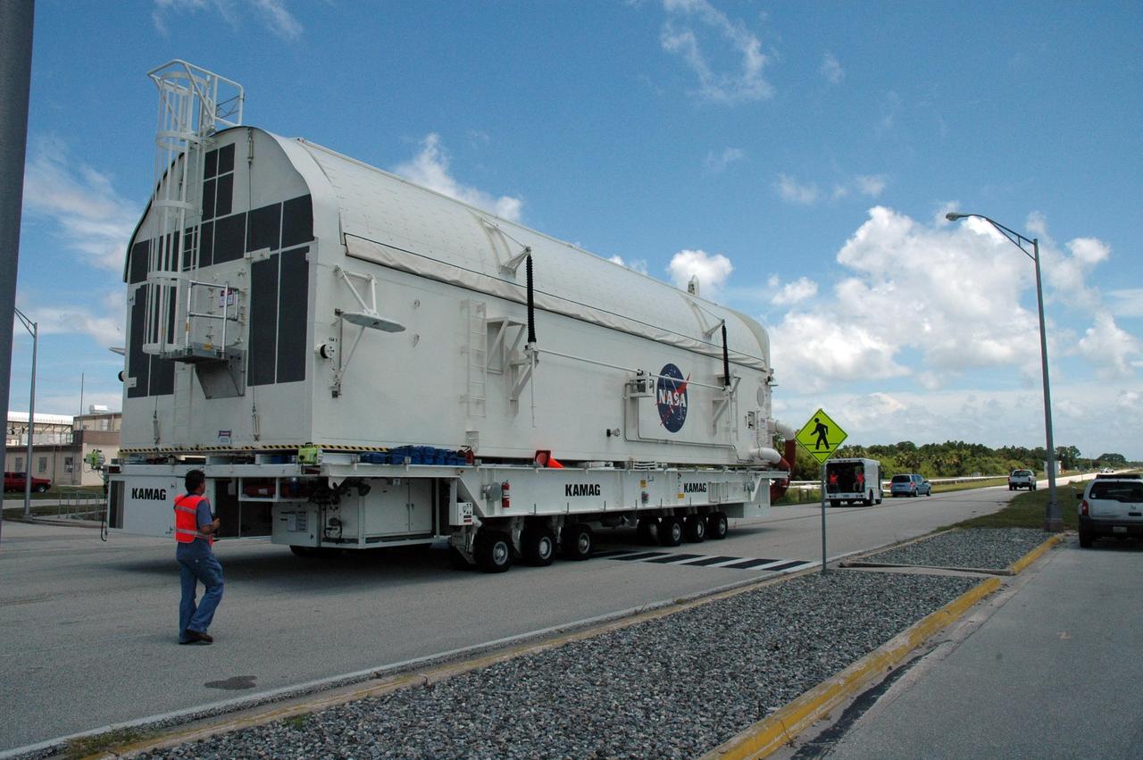 KENNEDY SPACE CENTER, FLA. --   The STS-118 payload canister transporter moves from the Space Station Processing Facility to the Canister Rotation Facility.  Inside the canister are the SPACEHAB module, the S5 truss and the external stowage platform 3.  At the CRF, the canister will be raised to a vertical position for delivery to Launch Pad 39A.  Endeavour is targeted for launch on Aug. 9 to the International Space Station. The mission will continue space station construction with installation of the truss.  Photo credit: NASA/Jim Grossmann