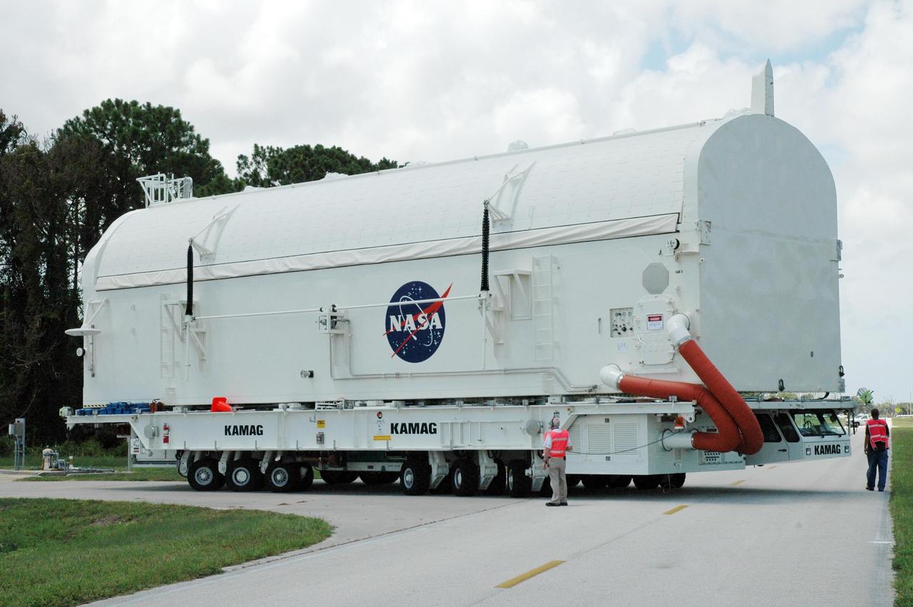 KENNEDY SPACE CENTER, FLA. --  The STS-118 payload canister transporter turns the corner toward the Canister Rotation Facility.  Inside the canister are the SPACEHAB module, the S5 truss and the external stowage platform 3.  At the CRF, the canister will be raised to a vertical position for delivery to Launch Pad 39A.  Endeavour is targeted for launch on Aug. 9 to the International Space Station. The mission will continue space station construction with installation of the truss.  Photo credit: NASA/Jim Grossmann