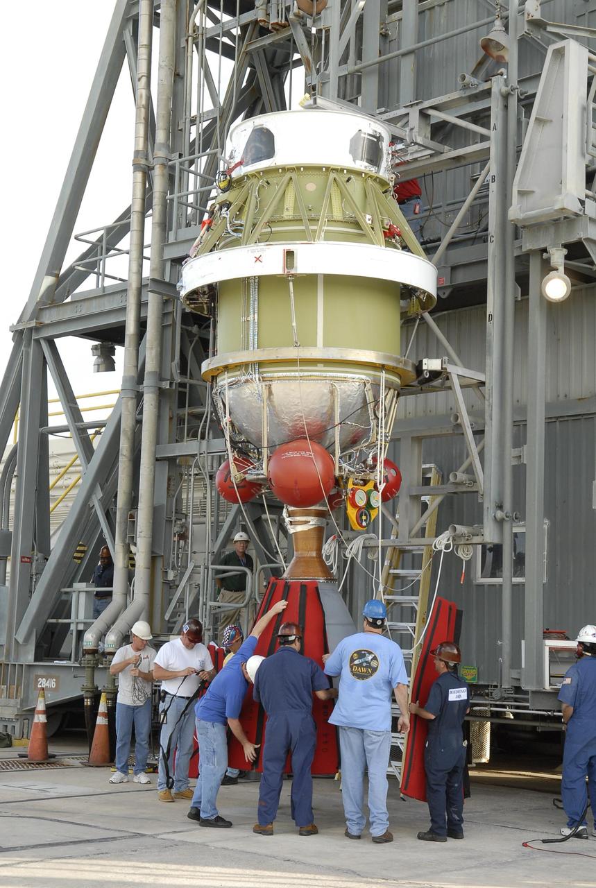 KENNEDY SPACE CENTER, FLA. -- On Launch Pad 17-A at Cape Canaveral Air Force Station, the second stage of the Delta II launch vehicle for NASA's Phoenix Mars Lander is suspended in front of the mobile service tower while workers place protective panels around the nozzle. The second stage will be lifted into the mobile service tower and mated with the Delta's first stage. Phoenix is scheduled to launch Aug. 3. Phoenix will land in icy soils near the north polar permanent ice cap of Mars and explore the history of the water in these soils and any associated rocks, while monitoring polar climate. Landing on Mars is planned in May 2008 on arctic ground where a mission currently in orbit, Mars Odyssey, has detected high concentrations of ice just beneath the top layer of soil. Photo credit: NASA/Kim Shiflett