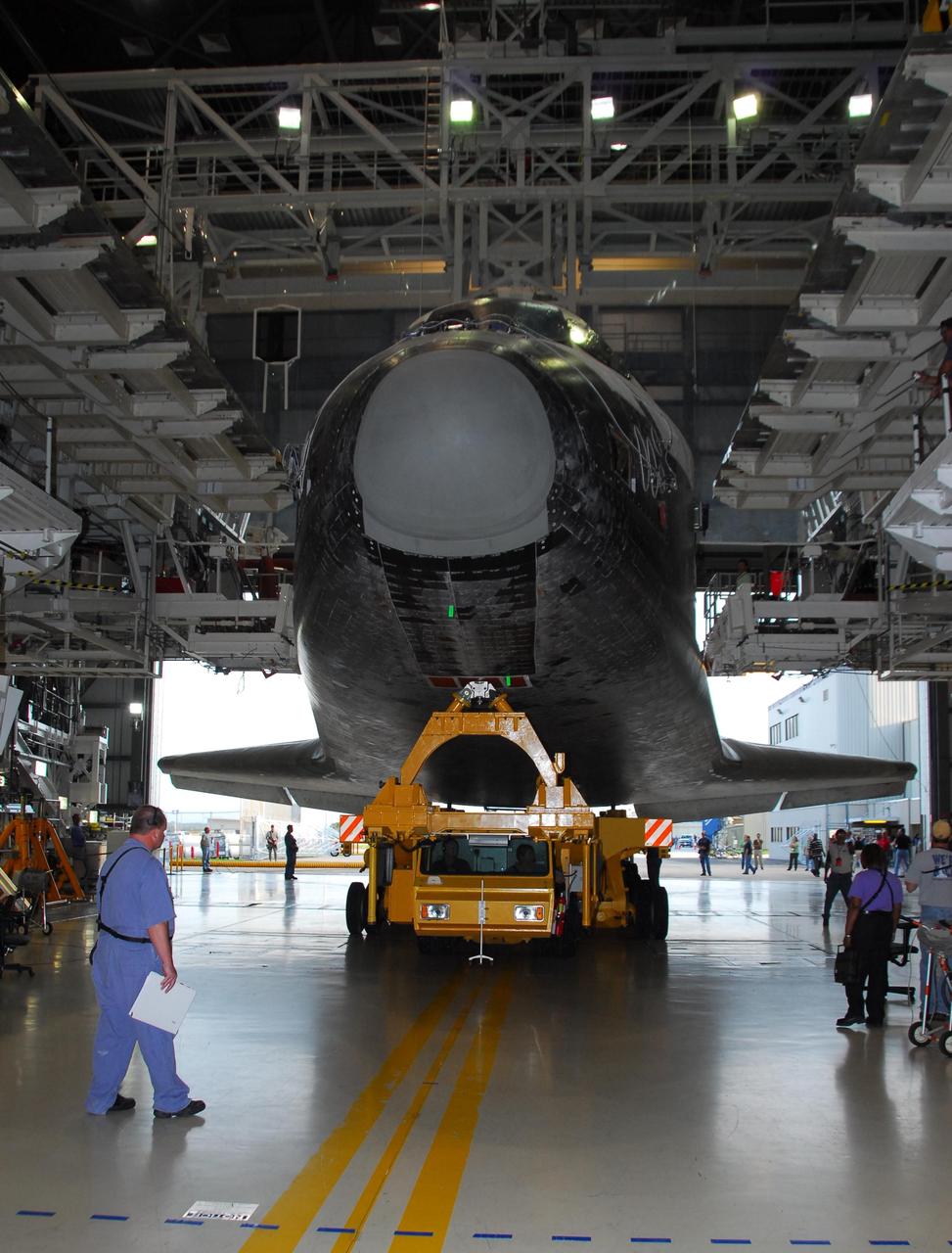 KENNEDY SPACE CENTER, FLA. --  Viewed from inside, the orbiter Endeavour rolls out of Orbiter Processing Facility bay 2 on its transporter.  It is headed for the Vehicle Assembly Building where it will be stacked with the external tank and solid rocket boosters atop the mobile launcher platform for its launch on mission STS-118. The mission will be Endeavour's first flight in more than four years. The shuttle has undergone extensive modifications, including the addition of safety upgrades already added to shuttles Discovery and Atlantis. Endeavour also features new hardware, such as the Station-to-Shuttle Power Transfer System that will allow the docked shuttle to draw electrical power from the station and extend its visits to the orbiting lab.  Endeavour is targeted for launch on Aug. 7.   Photo credit: NASA/George Shelton